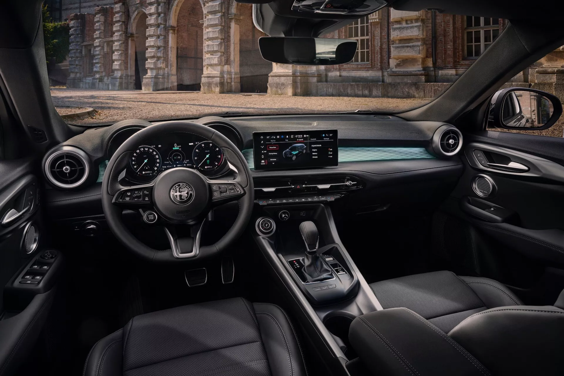 Vista interior do Alfa Romeo Tonale 2022 do assento traseiro do passageiro exibindo o cockpit, volante com controles, painel digital, tela horizontal de infotainment, console central com alavanca de câmbio e assentos de couro de luxo