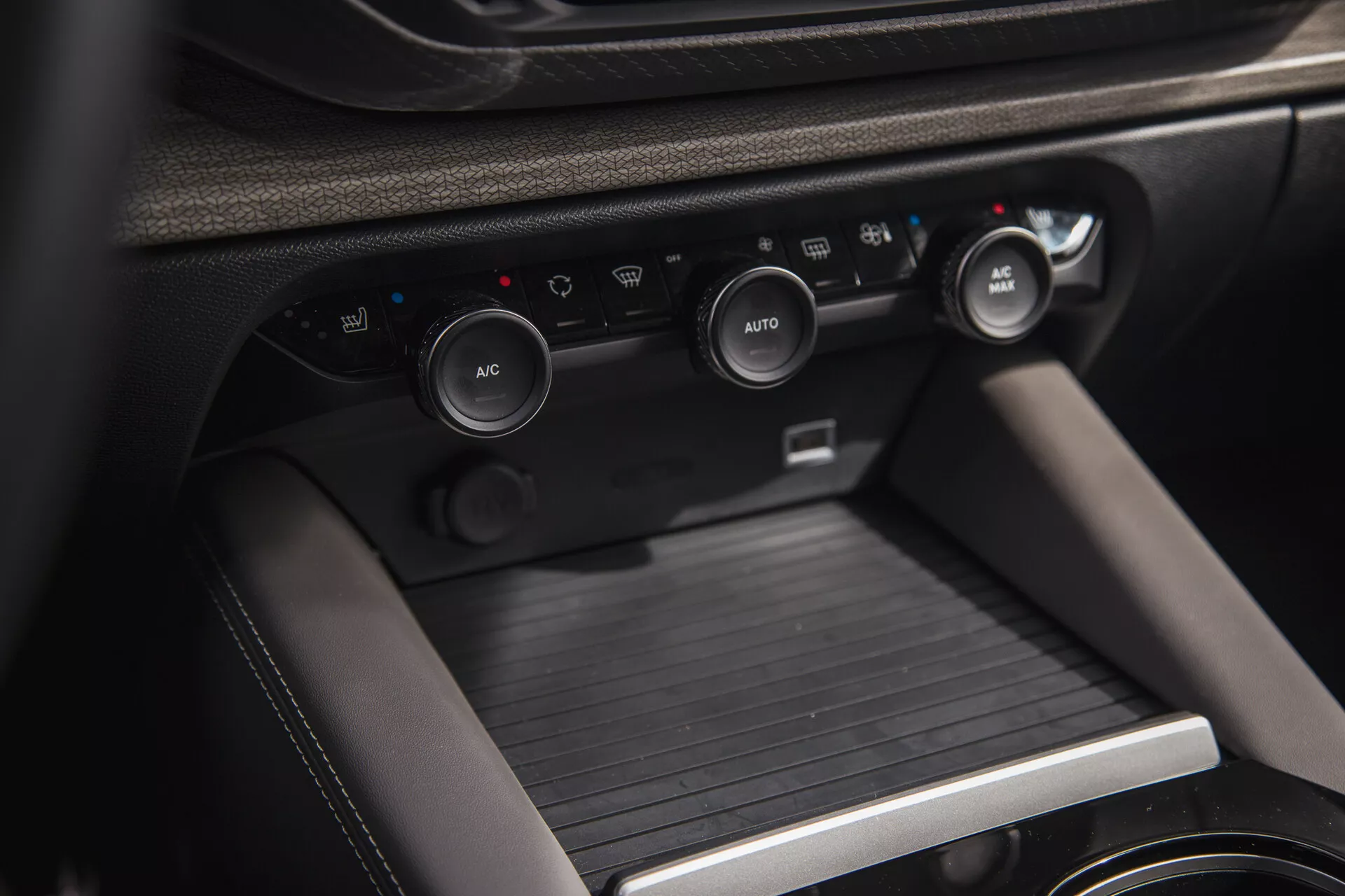 Vista detalhada do interior do Citroen C5-X 2022, apresentando o console central com os botões de controle climático e o console de mudança de marchas, destacando o sistema climático avançado do veículo, soluções de armazenamento e materiais premium.