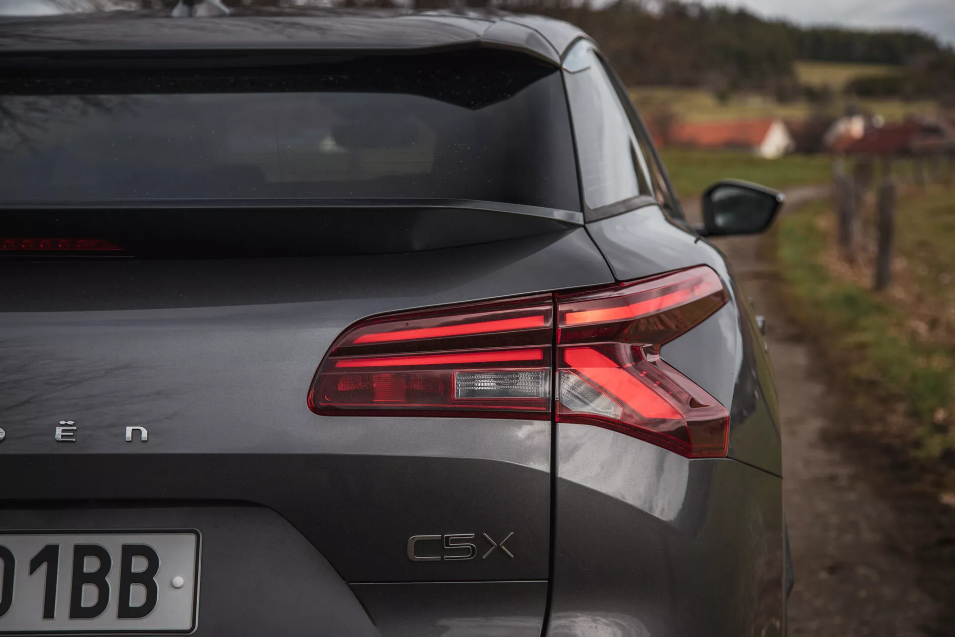 Seção traseira do Citroen C5-X 2022 em um ângulo oblíquo mostrando luzes traseiras de LED, acabamento brilhante e marcação do modelo