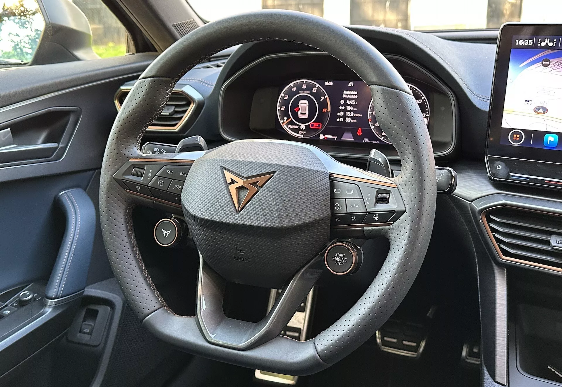 Vista interior do cockpit do Cupra Formentor 2020, com volante sensível ao toque com logotipo da marca, painel de instrumentos digital e sistema de infotenimento com tela grande.