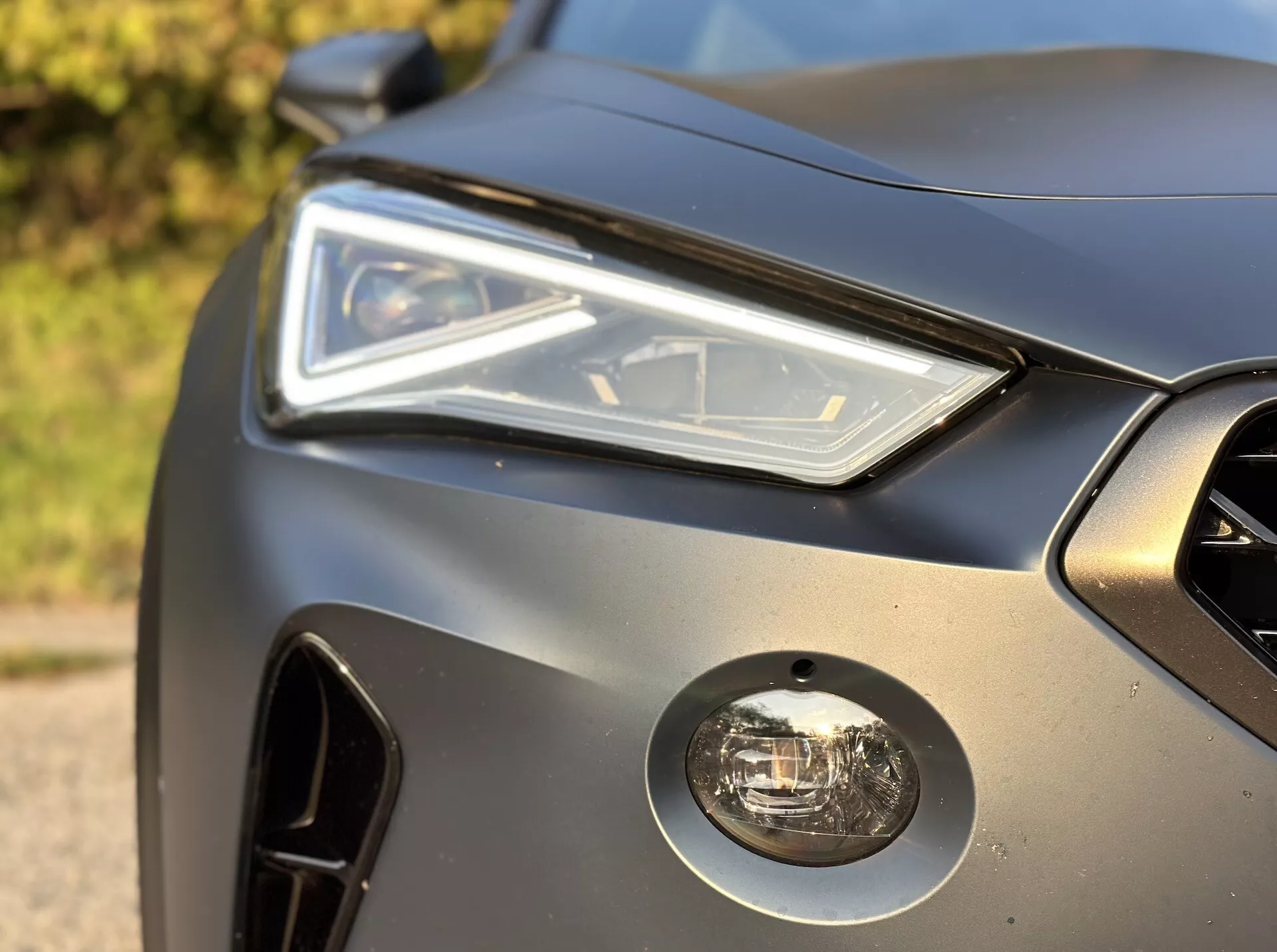 Close-up do canto frontal do Cupra Formentor 2020 apresentando conjunto de farol LED, farol de neblina, grade frontal e design elegante do painel da carroceria com acabamento fosco