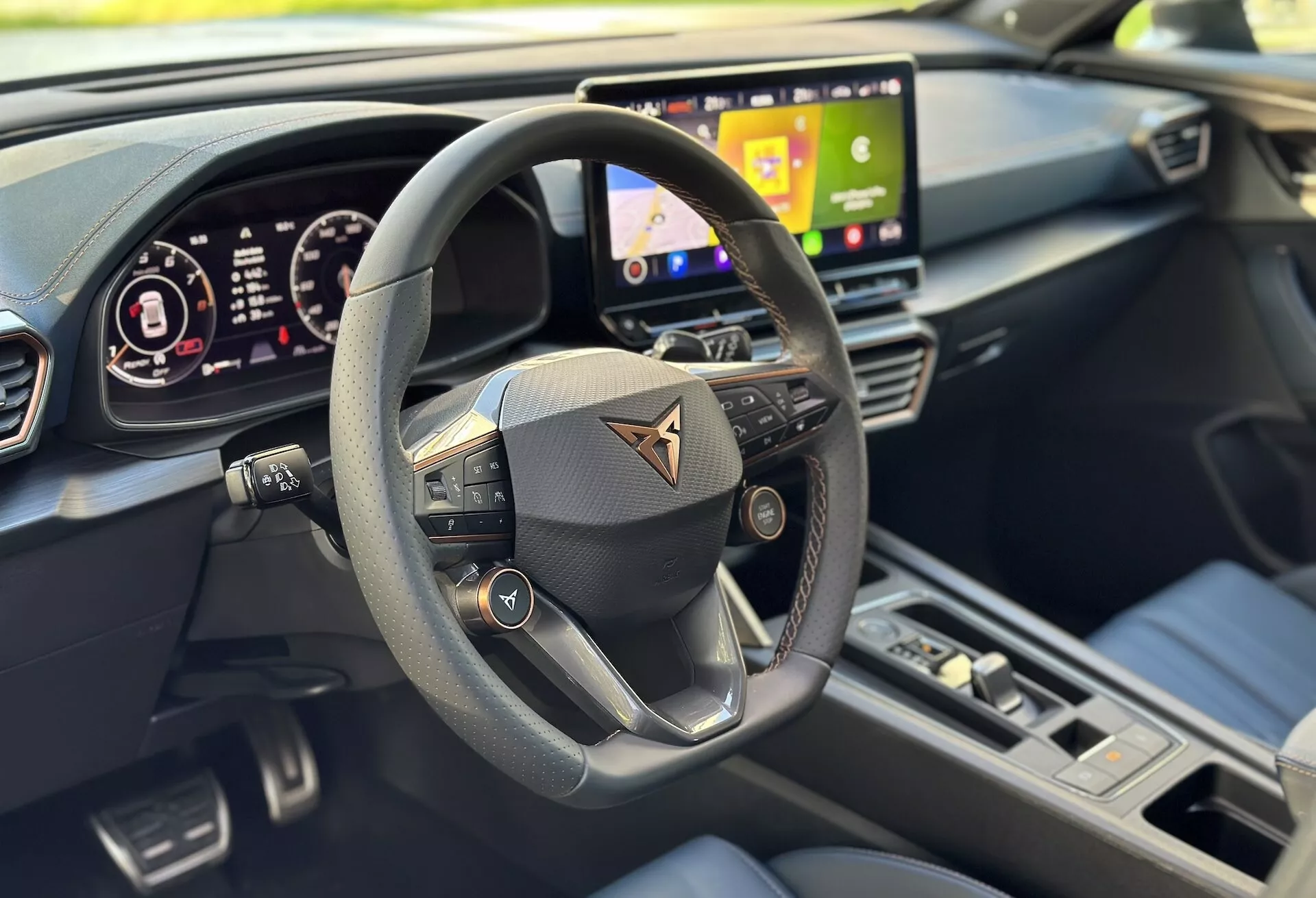 Vista interior do Cupra Formentor 2020 focada na perspectiva do motorista com uma visão clara do volante multifunções, painel digital e parte do sistema de infotainment, destacada por um design moderno e características de tecnologia avançada