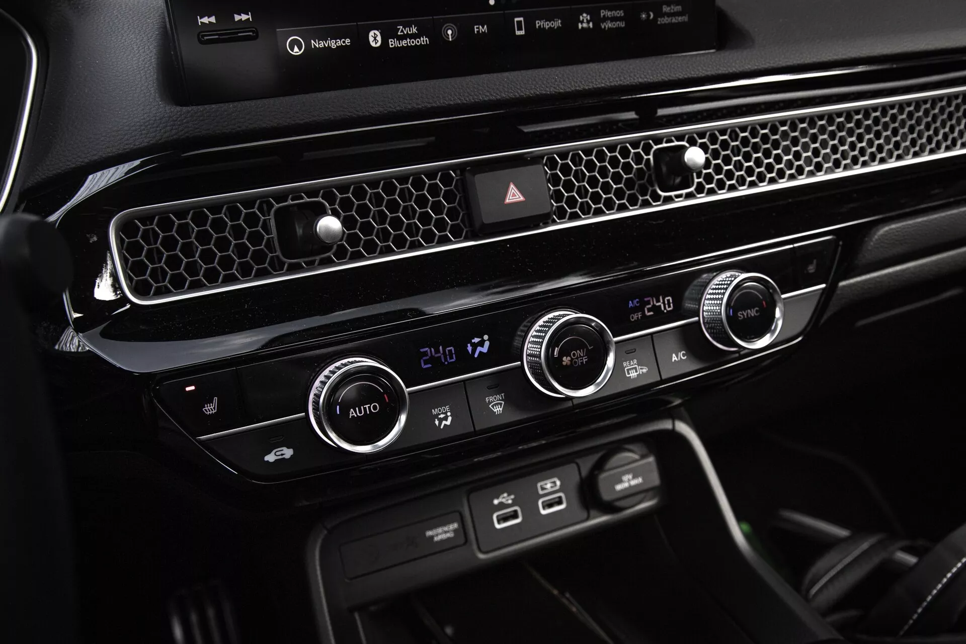 Console central e unidade de controle climático do Honda Civic 2022 mostrando configurações de temperatura de zona dupla, ventilação com acentos em cromo e botões de função dedicados para um design de interior moderno e simplificado