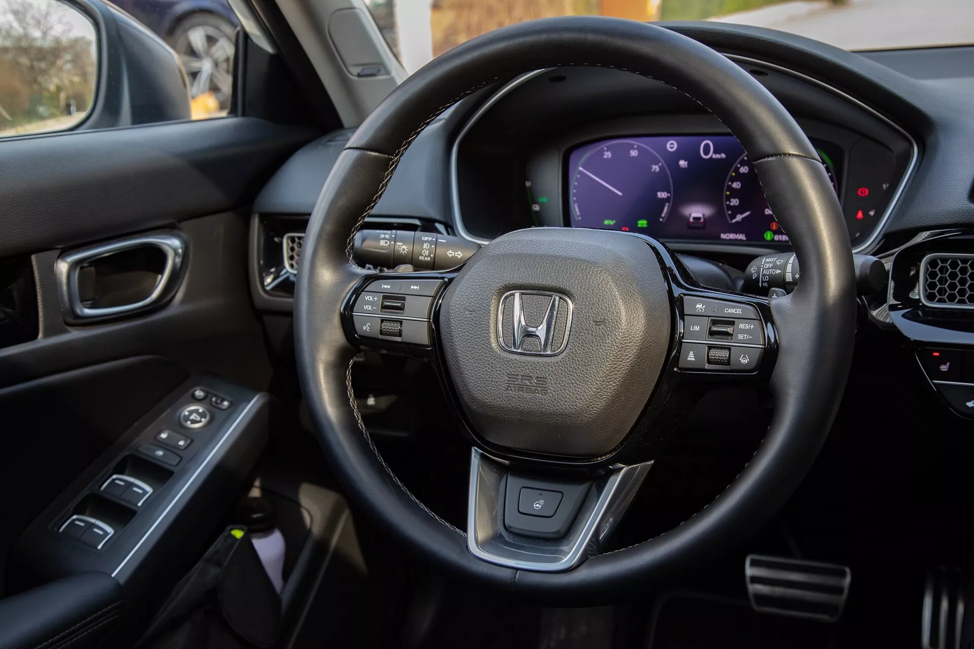 Vista interior do Honda Civic 2022 do assento do motorista, destacando o volante revestido em couro com controles multifuncionais, cluster de instrumentos digital, parte do console central com tela touchscreen e controles na porta do motorista para uma exibição abrangente das características tecnológicas modernas e design de luxo do veículo.