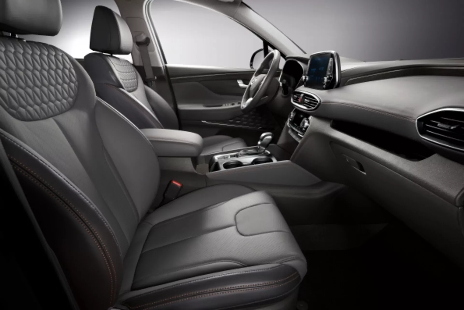Interior do Hyundai Santa Fe 2015 exibindo assentos com estofado de couro acolchoado, painel de instrumentos digital, sistema de infotenimento touchscreen e console central elegante com iluminação ambiente