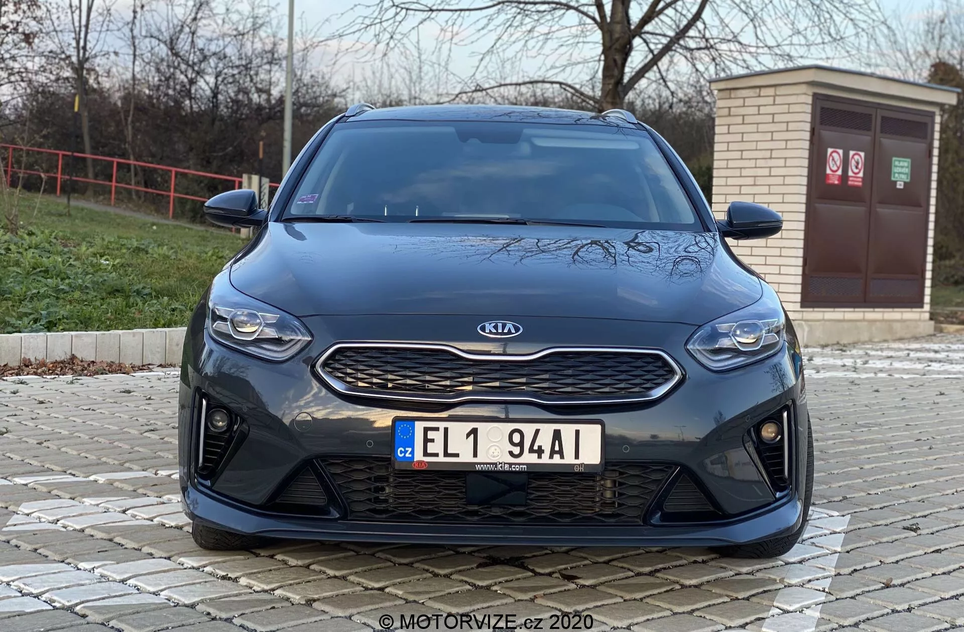 Vista frontal de um carro Kia Ceed 2018 de um ângulo baixo, destacando características frontais como a grade, faróis e para-choques com uma estética moderna. A imagem destaca o emblema prateado da Kia em uma grade texturizada preta, faróis horizontais elegantes e o para-choques dianteiro com grandes entradas de ar, sugerindo características de desempenho esportivo ou refrigeração avançada por fluxo de ar.