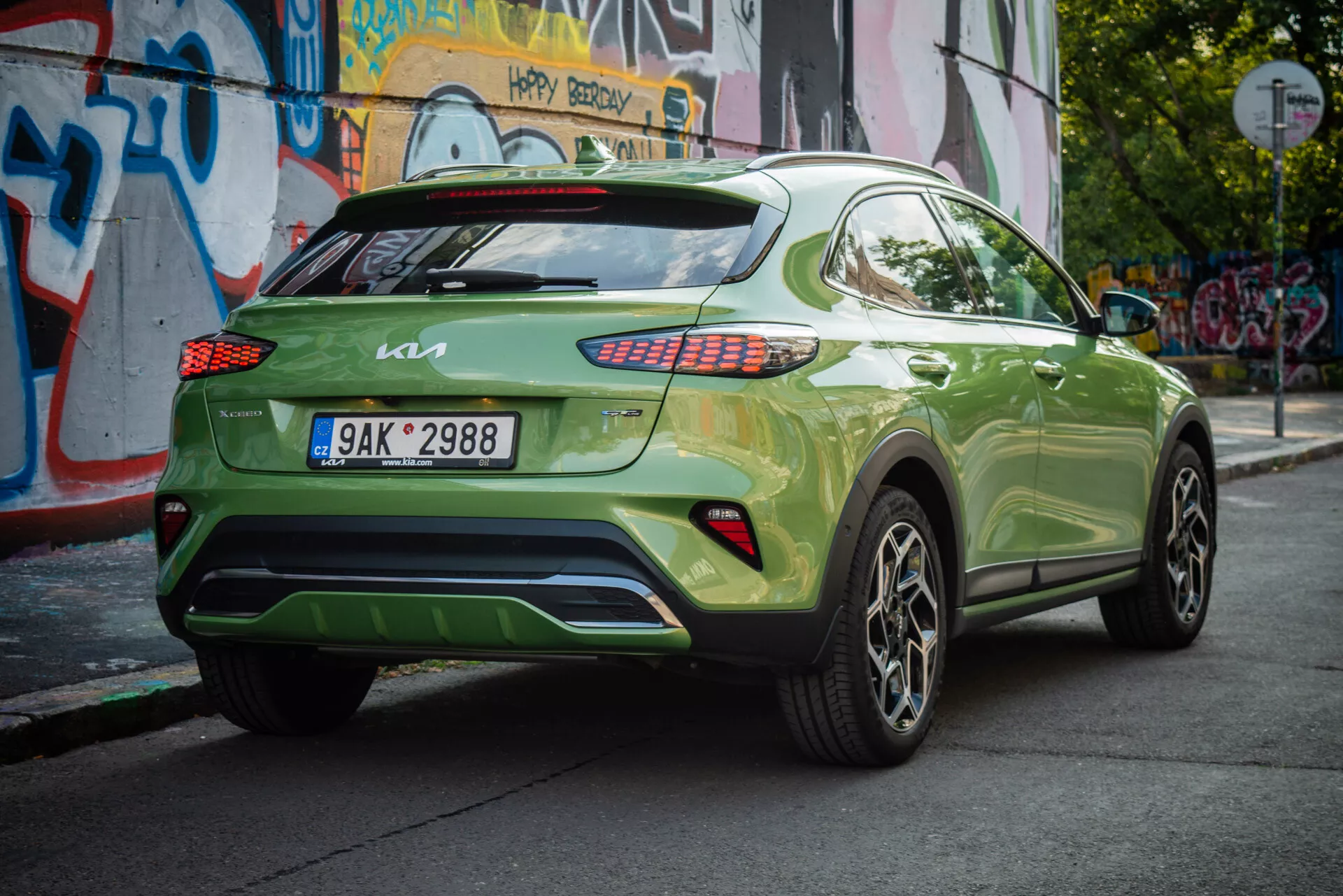 Kia XCeed 2022 em verde vibrante, mostrando seu ângulo traseiro de três quartos com placa europeia, lanternas traseiras LED, rodas de liga e fundo urbano.