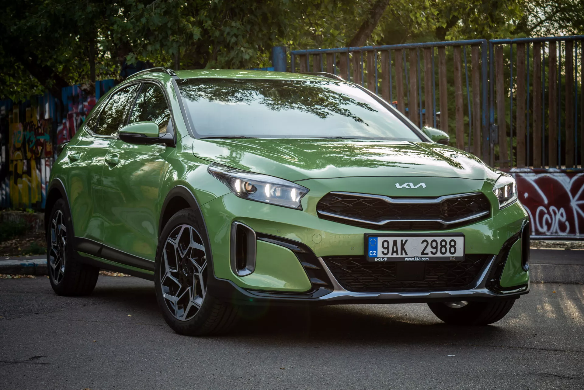 Kia Xceed 2022 verde estacionado em ângulo, mostrando sua vista frontal de três quartos com faróis LED e rodas de liga esportiva em um ambiente urbano