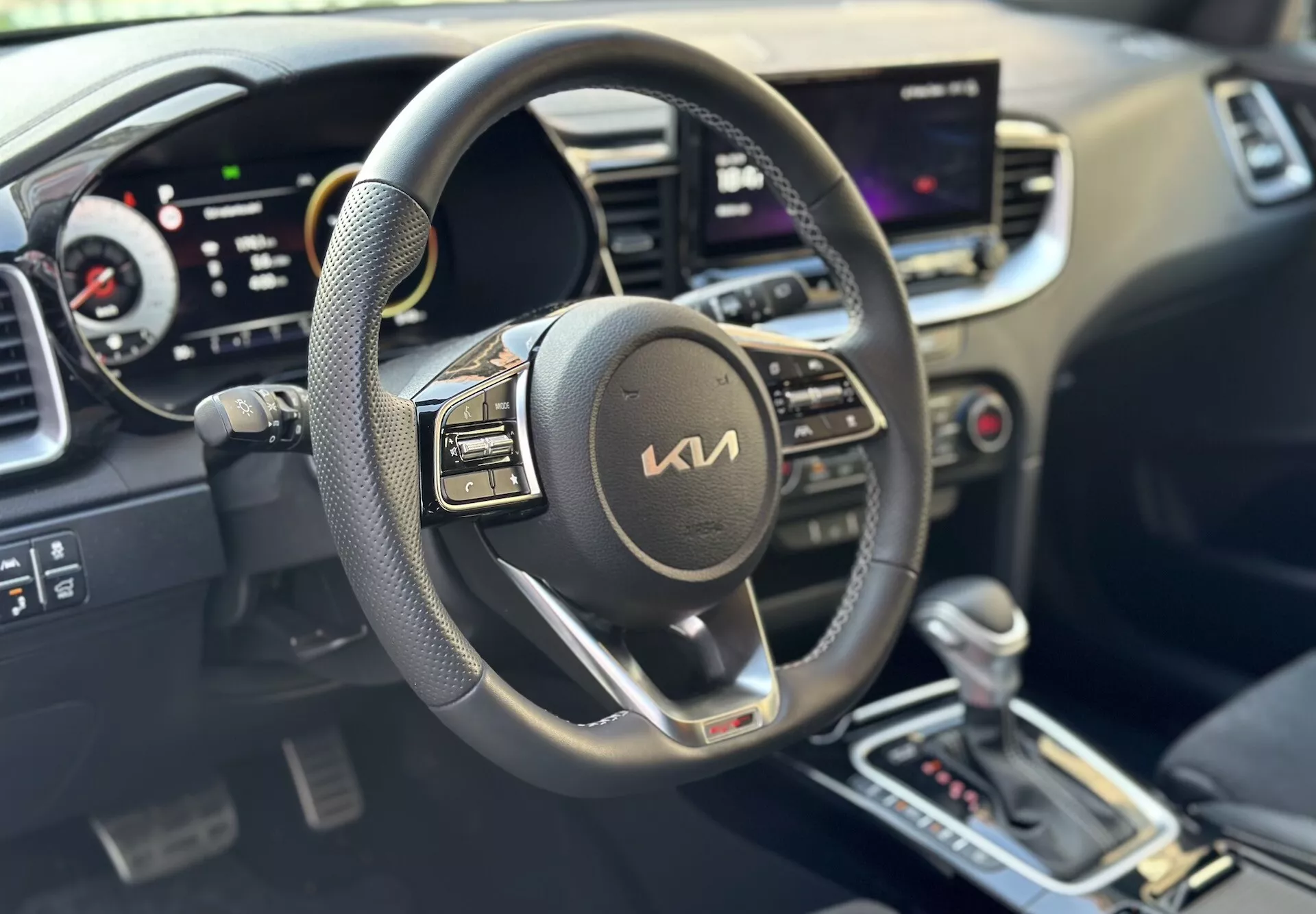 Interior do Kia Xceed 2022 focado no lado do motorista com volante, painel digital e sistema central de infotenimento touchscreen indicativo de tecnologia moderna e conveniência