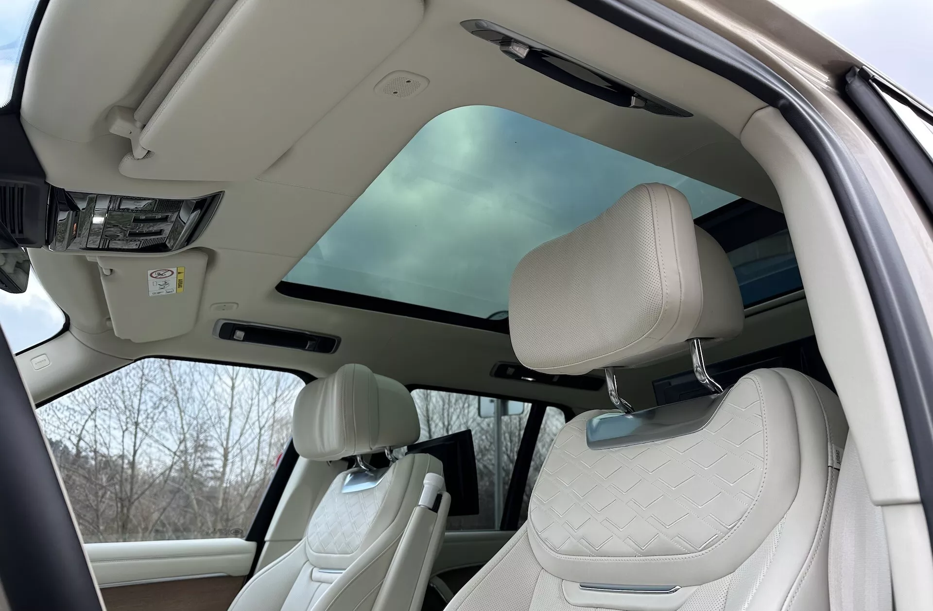 Vista interior do Land Rover Range Rover 2021 destacando a cabine de luxo com teto solar panorâmico, bancos dianteiros acolchoados e comodidades avançadas na cabine