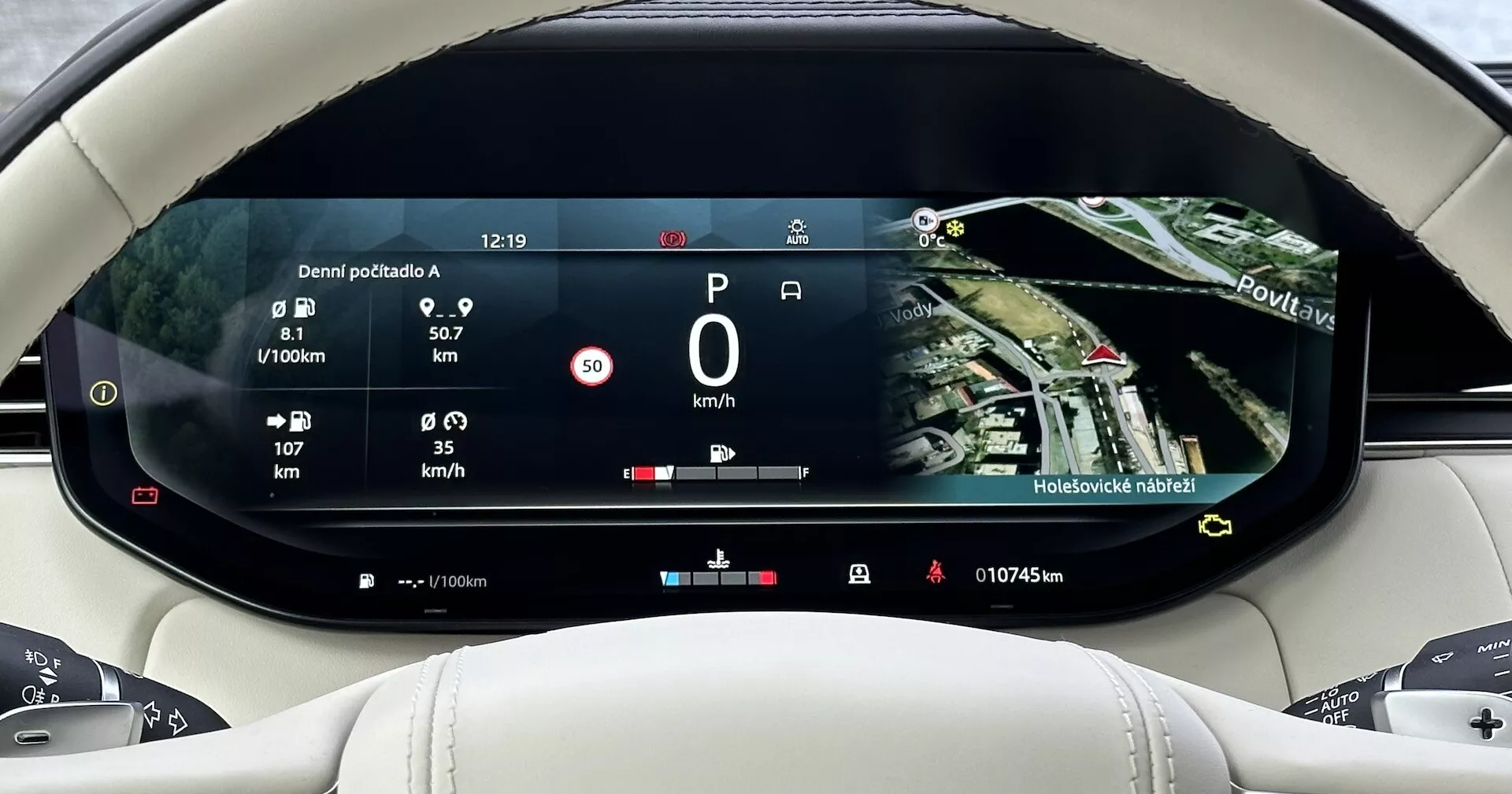 Painel digital do Land Rover Range Rover 2021 exibindo informações de viagem, eficiência de combustível, velocidade e um mapa de navegação por satélite, visto da perspectiva do condutor