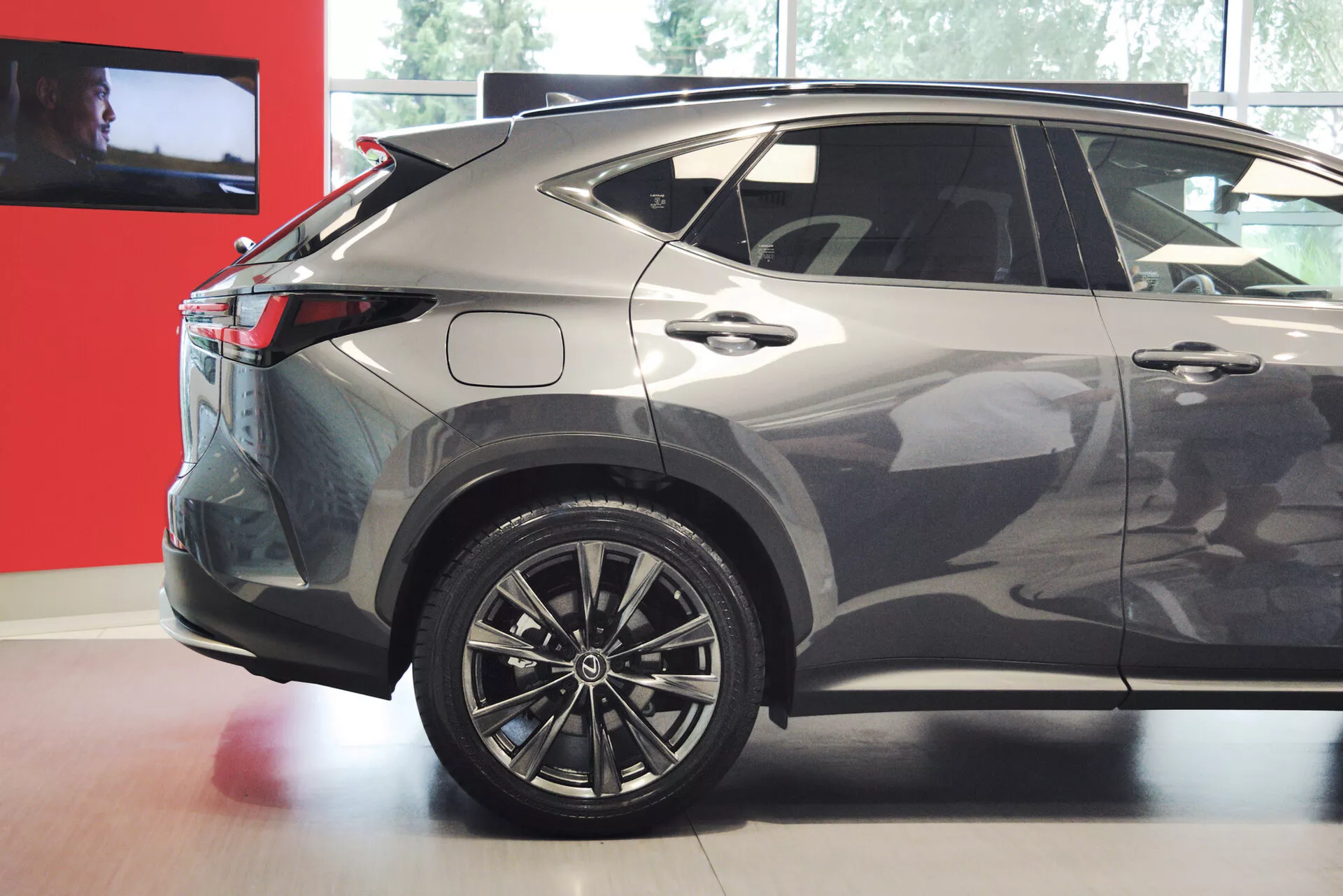 A imagem mostra a vista traseira de três quartos de um SUV crossover moderno, compacto ou médio, enfatizando o lado direito. As características visíveis incluem rodas de liga leve com design de múltiplos raios, luzes traseiras de LED, uma linha de teto inclinada, janelas traseiras escurecidas, um acabamento de pintura metálica, linhas nítidas da carroceria, um spoiler traseiro integrado, uma antena de barbatana de tubarão e um acabamento inferior de plástico. O design do veículo indica um perfil esportivo e aerodinâmico, adequado para discussões sobre design automotivo, tecnologia e recursos.