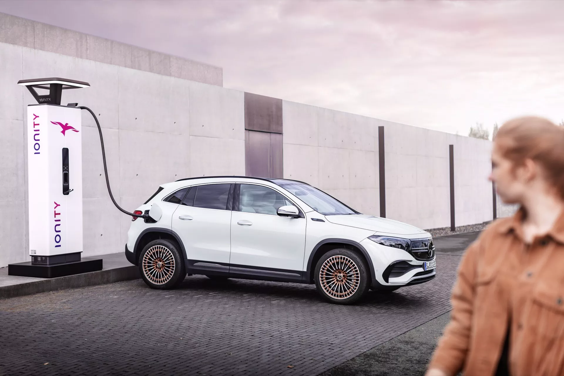 Carro elétrico Mercedes-Benz EQA de 2021 conectado a uma estação de carregamento IONITY, exibindo design elegante e recursos aerodinâmicos em um ambiente urbano