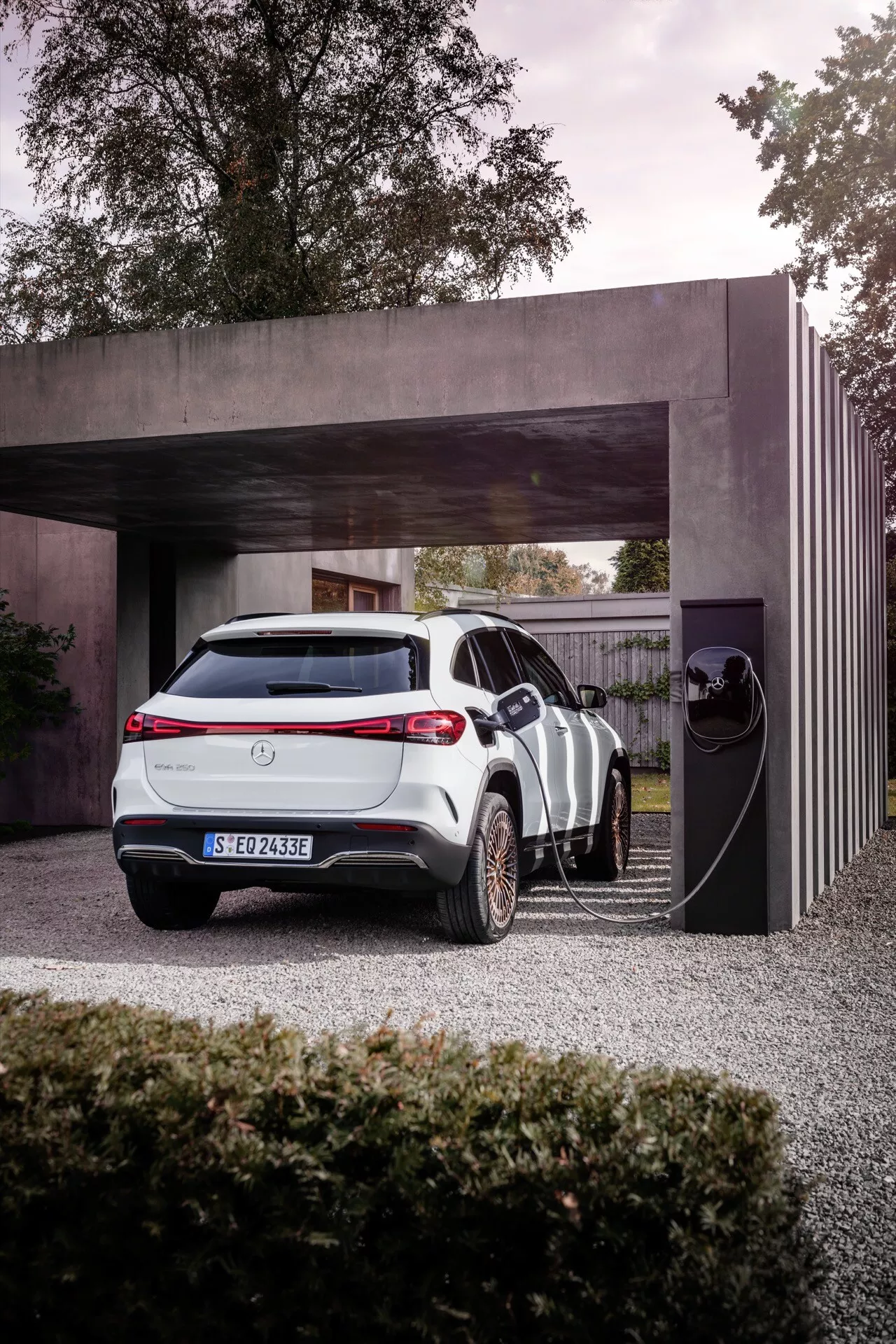 Veículo elétrico Mercedes-Benz EQA 2021 estacionado em uma estação de carregamento privada, destacando seu design elegante e características tecnológicas modernas contra um pano de fundo arquitetônico contemporâneo