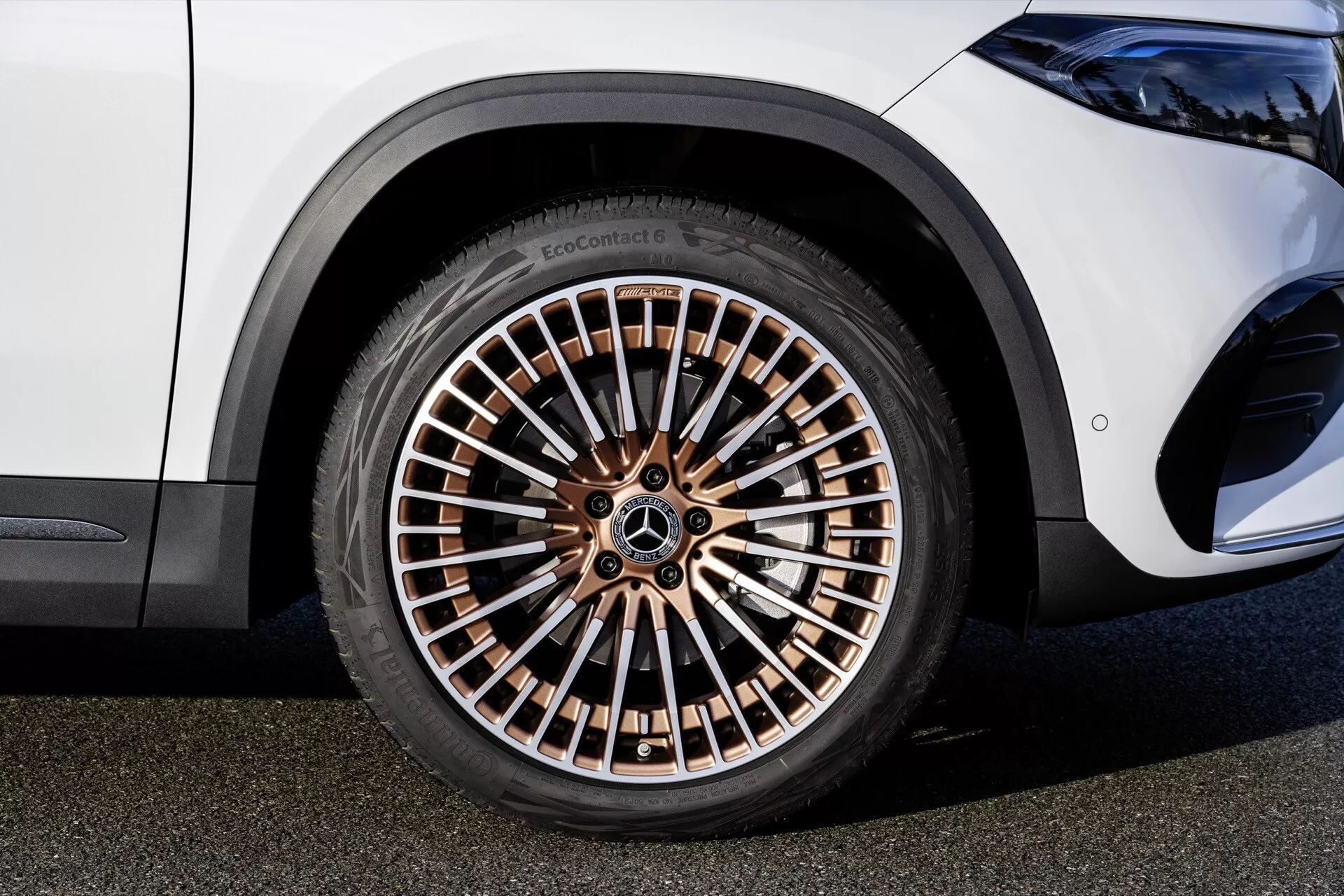 Vista de perto de uma roda da Mercedes-Benz EQA 2021 mostrando uma jante de múltiplos raios em tom de bronze e pneu de alto perfil EcoContact, refletindo elementos de design de luxo e ecológicos