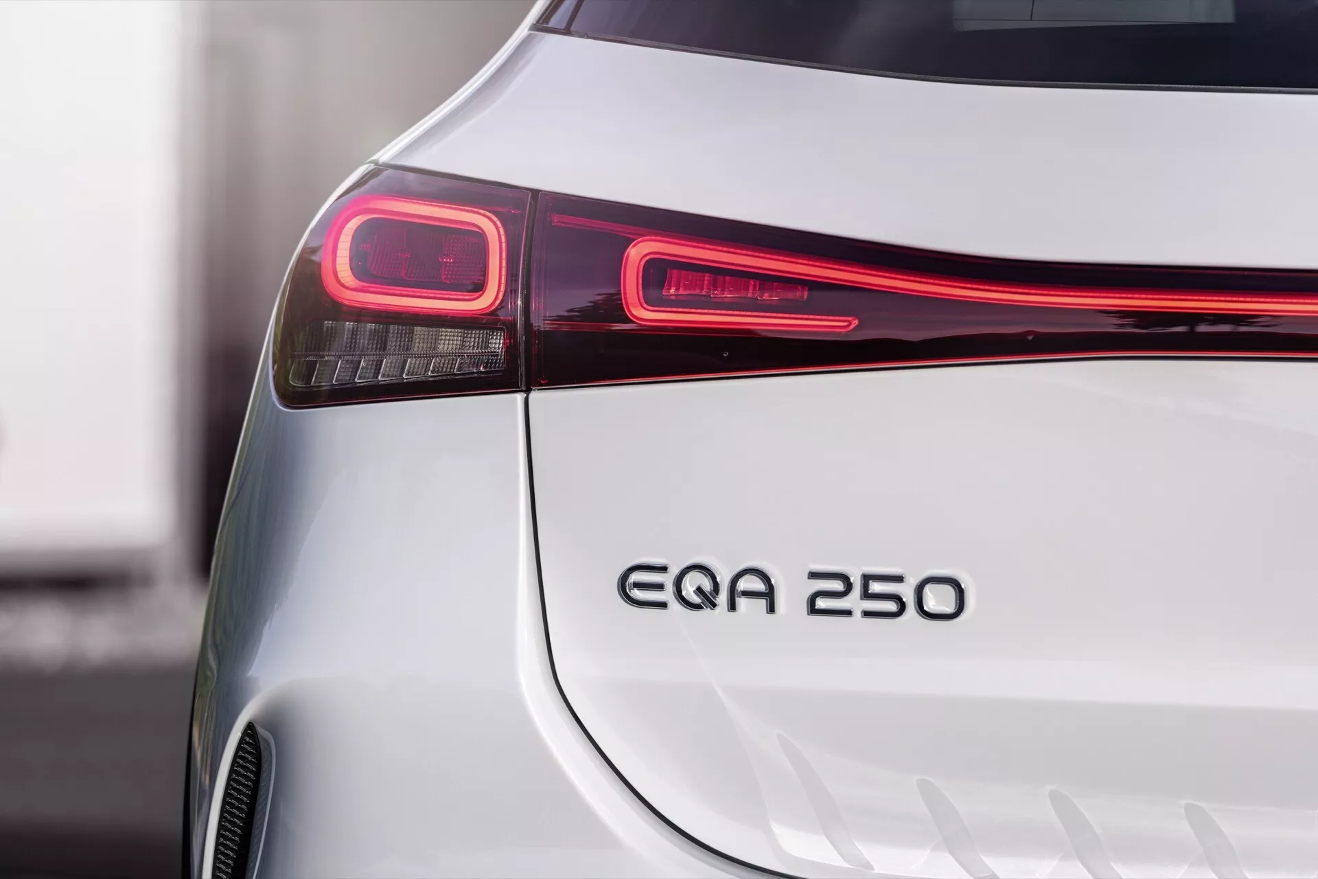 Imagem detalhada mostrando a elegante parte traseira de um Mercedes-Benz EQA 2021 prateado, destacando sua moderna luz traseira LED, distintivo EQA 250 e design do para-choque, indicativo de seu status de veículo elétrico