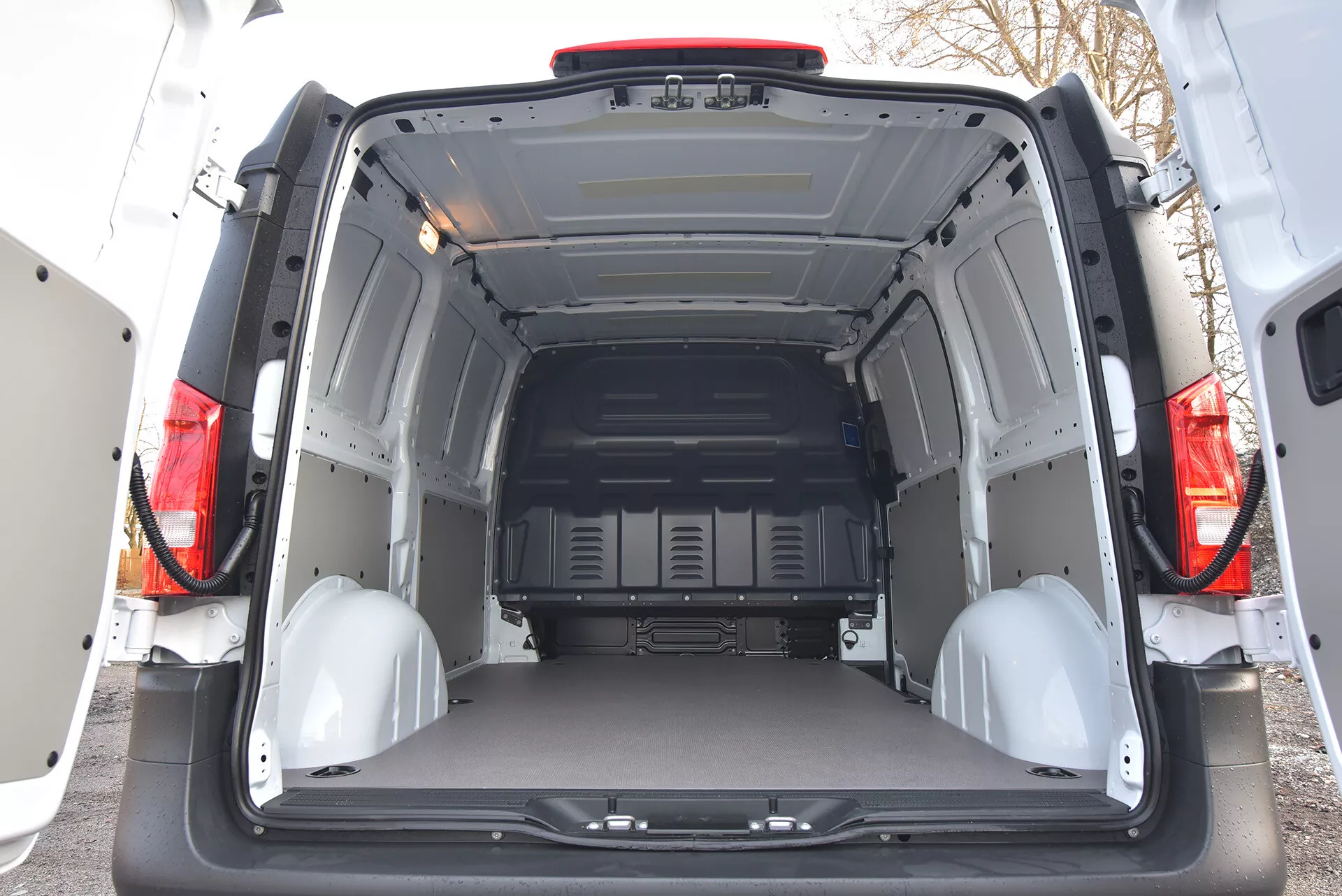 Vista interior traseira de um Mercedes-Benz Vito Tourer 2014 mostrando área de carga espaçosa e vazia com portas abertas, painéis de proteção e pontos de amarração