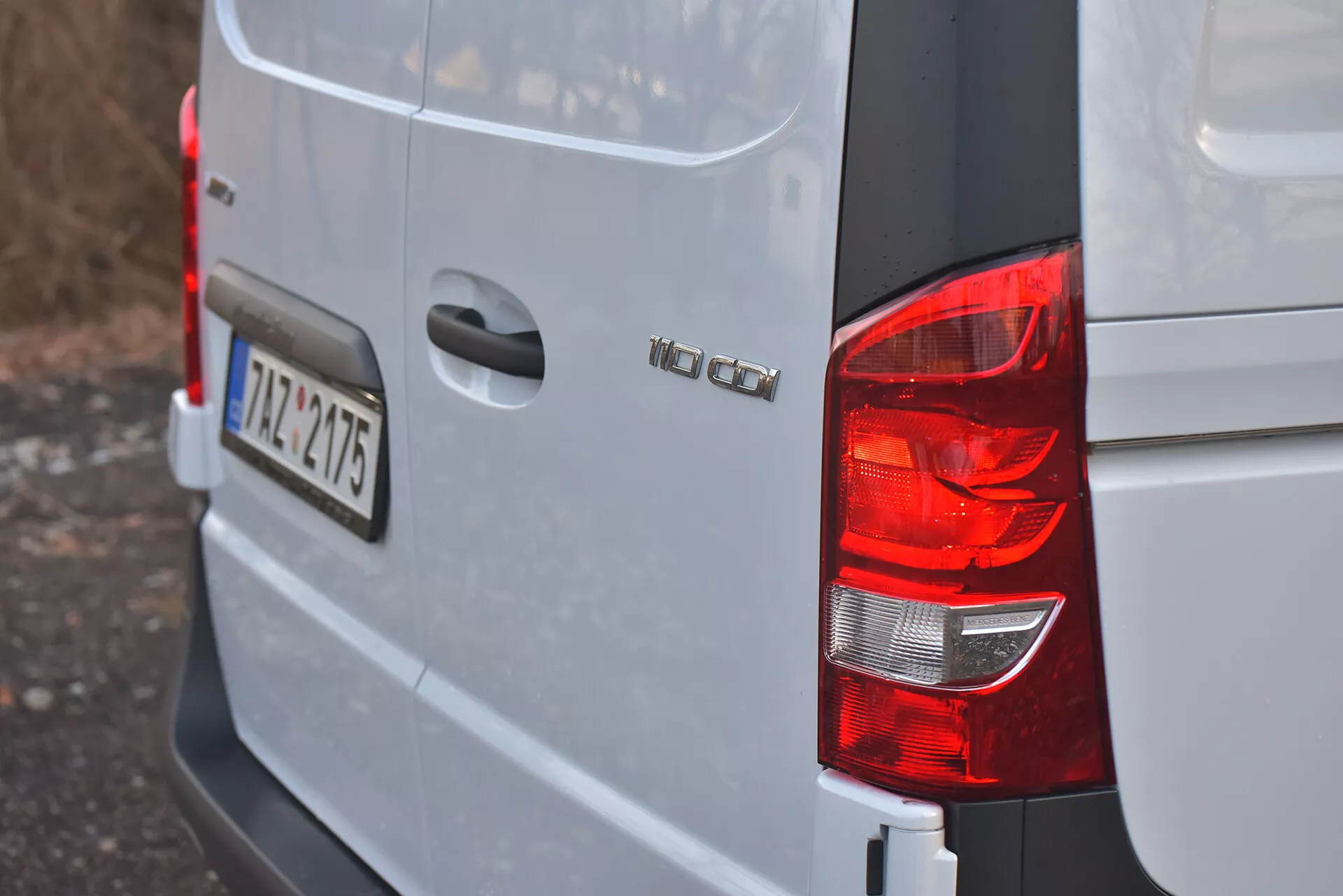 Vista do canto traseiro direito de uma van Volkswagen Vito 2014 Tourer prata ou cinza claro mostrando lanterna traseira, emblema do modelo 'VW CADDY', placa de licença ao estilo europeu '12-TZ-4715', e design de corpo quadrado típico de vans de carga compactas.
