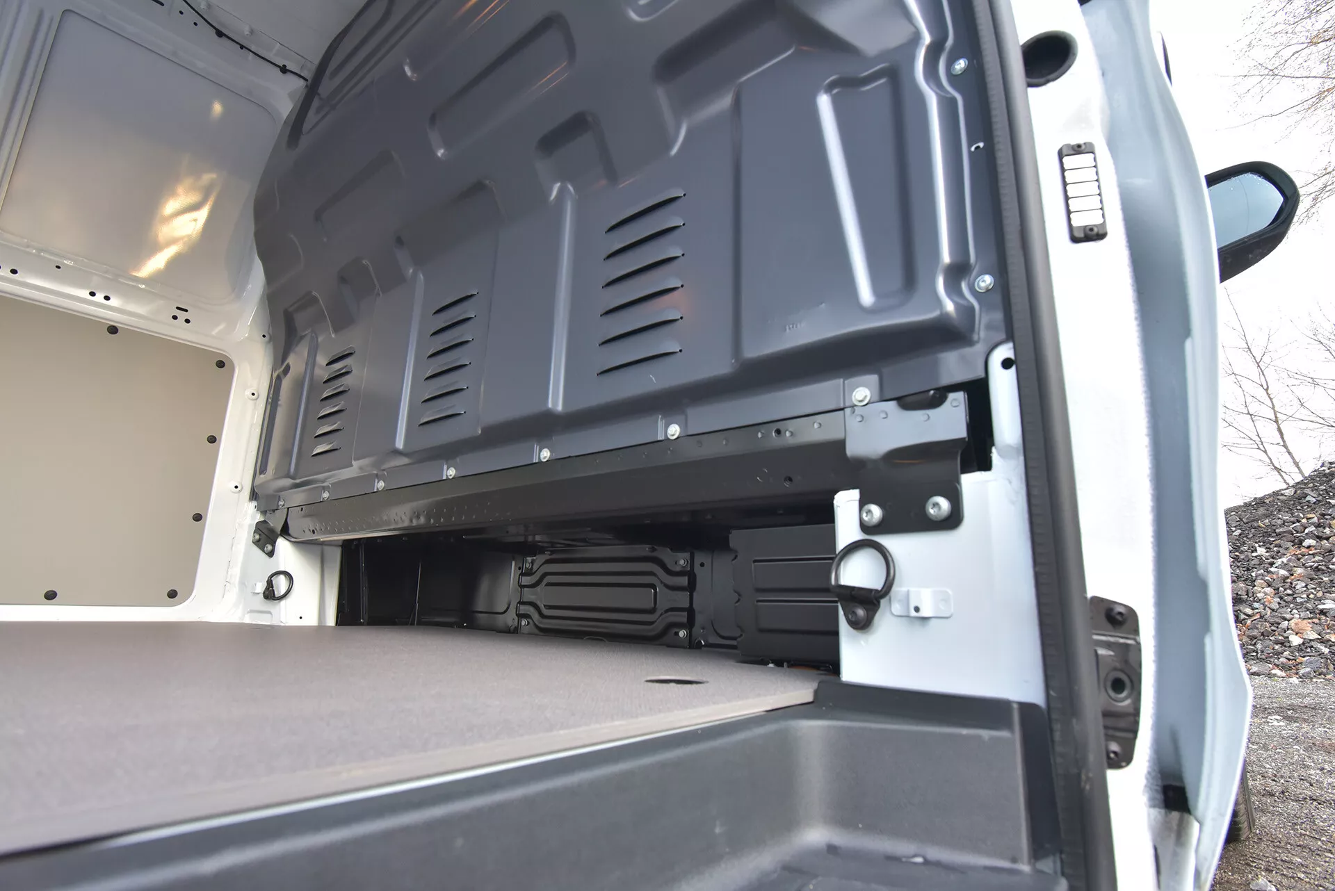 Vista interior traseira de uma van comercial Mercedes-Benz Vito Tourer de 2014, destacando a área de carga espaçosa com piso plano, portas abertas e superfícies duráveis para carregamento eficiente e transporte seguro.