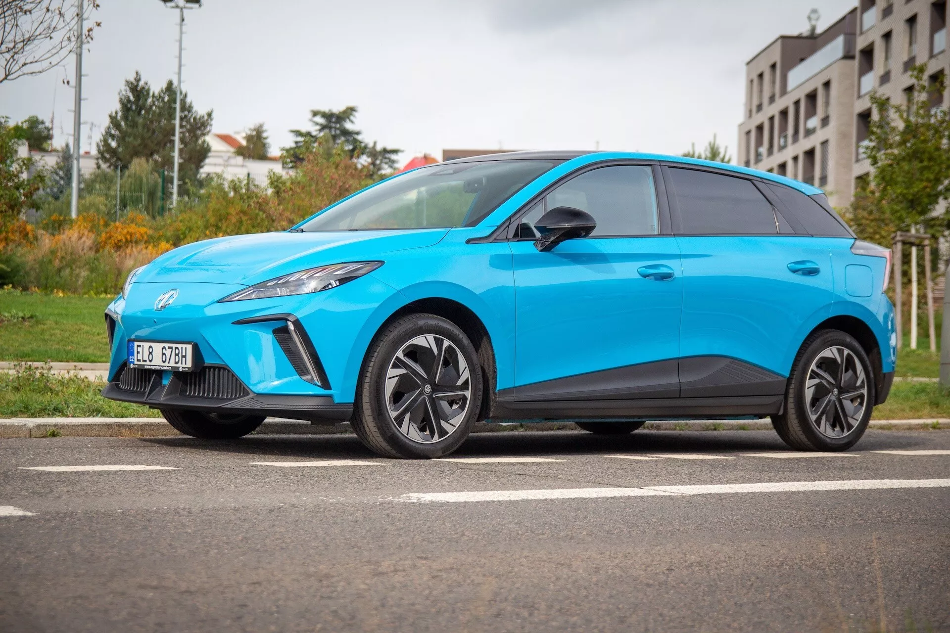 Hatchback elétrico MG MG4 2022 em azul brilhante, exibindo sua postura esportiva, perfil aerodinâmico e farol dianteiro esquerdo LED a partir de um ângulo lateral baixo