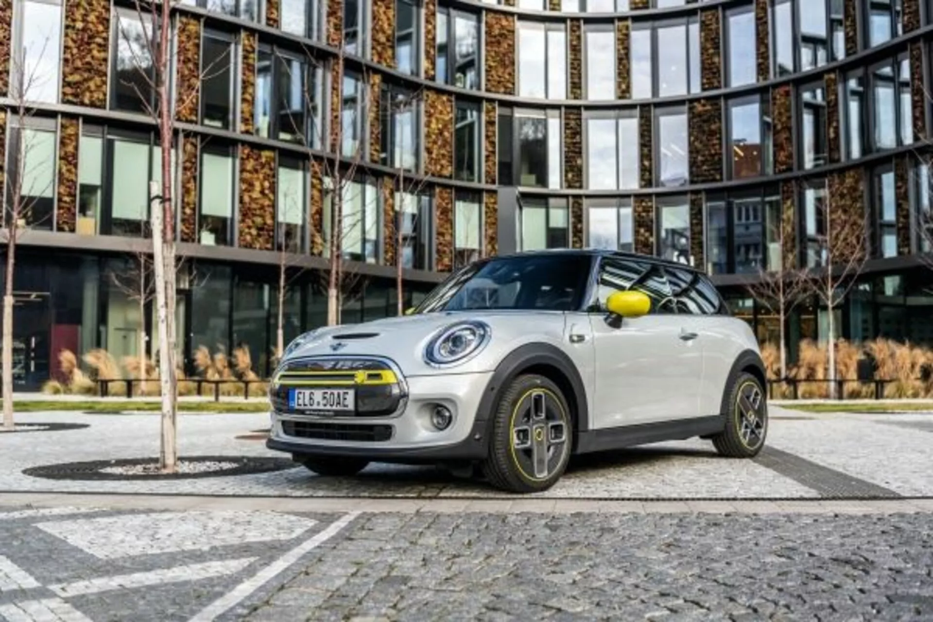 Mini Cooper 3 portas de 2018 em esquema de cores em dois tons apresentando para-choque frontal, grade, faróis LED e design único de roda de liga leve de uma perspectiva de ângulo baixo em ambiente urbano