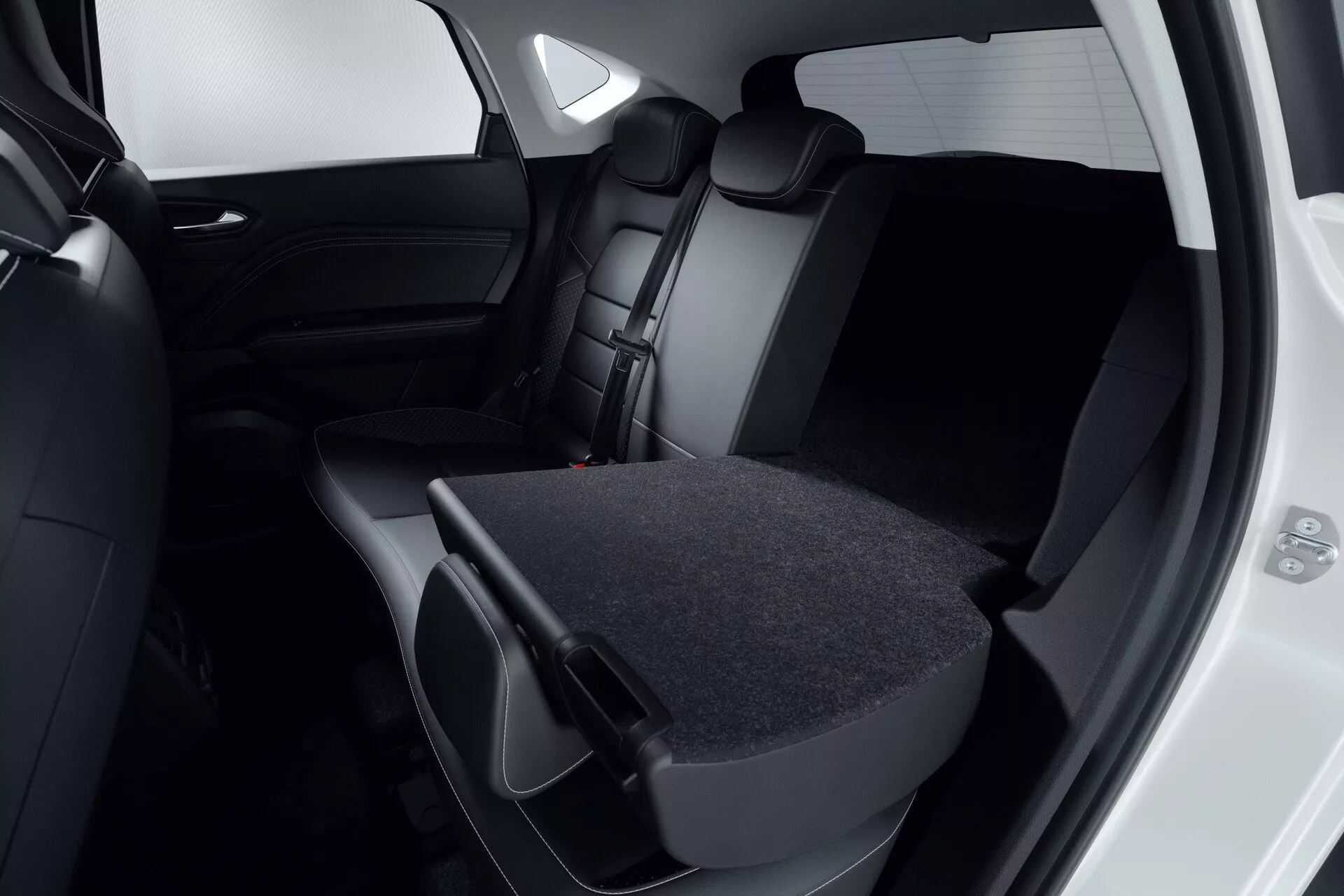 Vista aproximada do interior do passageiro traseiro do Mitsubishi ASX 2023 (2ª geração). Foco nos bancos estofados em material escuro, couro ou couro sintético, onde o banco traseiro direito está rebaixado, mostrando a flexibilidade da carga. A porta traseira está aberta revelando um interior escuro correspondente e vidros escurecidos. O design moderno e minimalista é evidente na paleta de cores preto ou cinza escuro. A imagem destaca a capacidade de armazenamento do veículo e o compromisso com a segurança com encostos de cabeça e cintos de segurança visíveis.