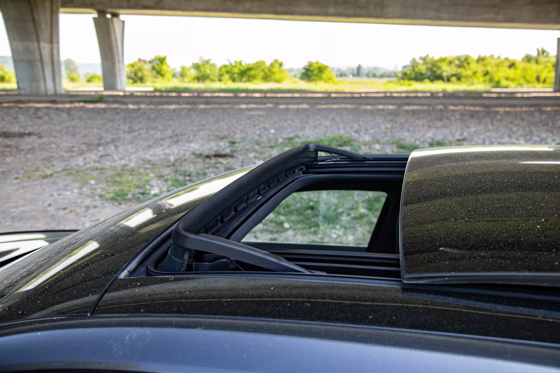 Visão detalhada do mecanismo da capota conversível do Peugeot 408 de 2023, focando nos pontos de conexão com a carroceria, capturada pelo lado do passageiro destacando o forro interno da capota, a vedação contra intempéries e a pintura externa.