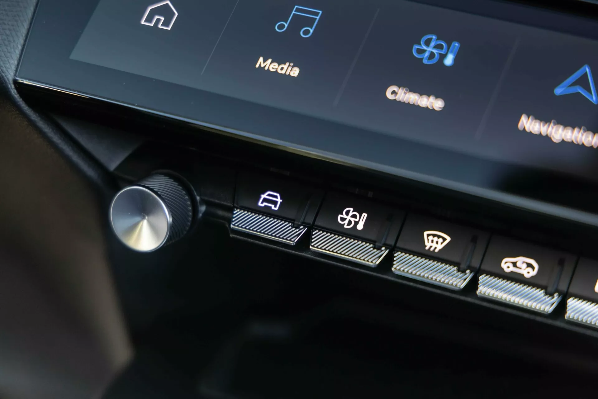 Interface de controle central do Peugeot 408 2023 exibindo botões táteis iluminados e parte da tela touchscreen com ícones de infotenimento e controle climático, destacando a tecnologia avançada do veículo