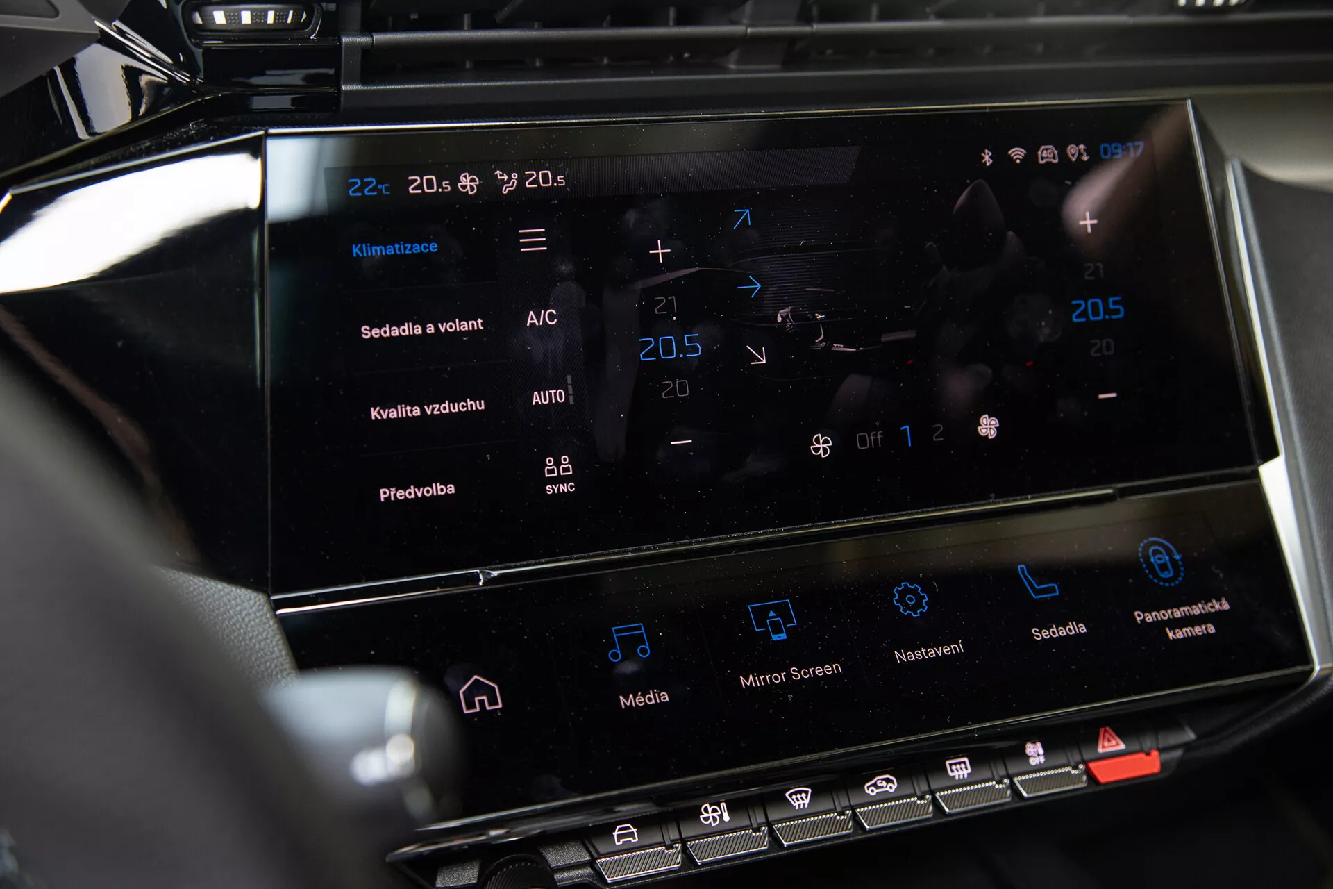 Console central do Peugeot 408 2023 mostrando o sistema de infotainment touchscreen e a interface de controle do clima com configurações de temperatura e recursos avançados