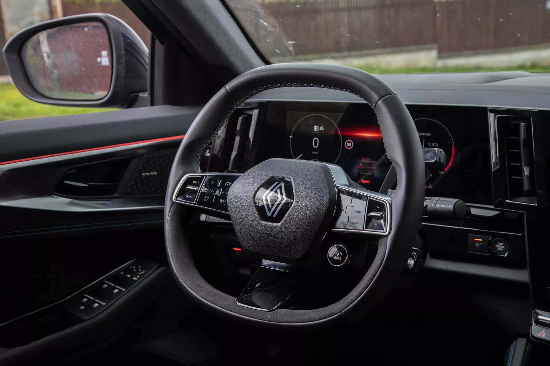 Foto do interior do Renault Austral 2022 pela perspectiva do motorista mostrando volante com controles montados, painel de instrumentos digital e parte do console central.
