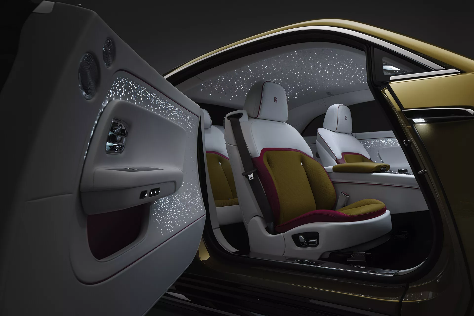 Vista interior detalhada a partir da perspectiva do passageiro traseiro esquerdo de um Rolls-Royce Spectre 2023, exibindo um design de luxo com bancos em dois tons, recursos de controle avançados e teto estrelado.