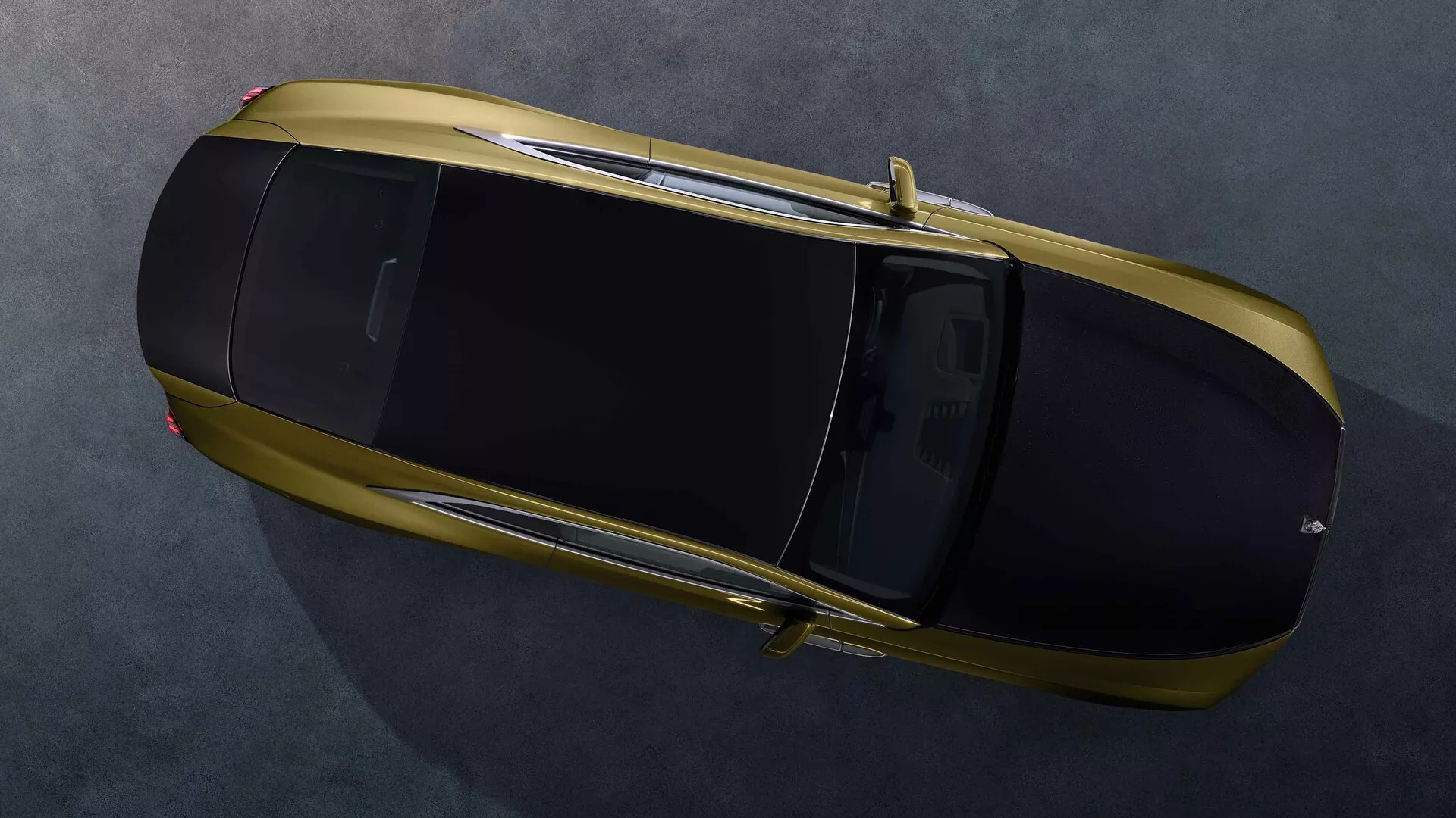 Rolls-Royce Spectre 2023 de 1ª geração em bronze visto de uma perspectiva aérea mostrando teto panorâmico, superfície superior completa e linhas de design elegantes