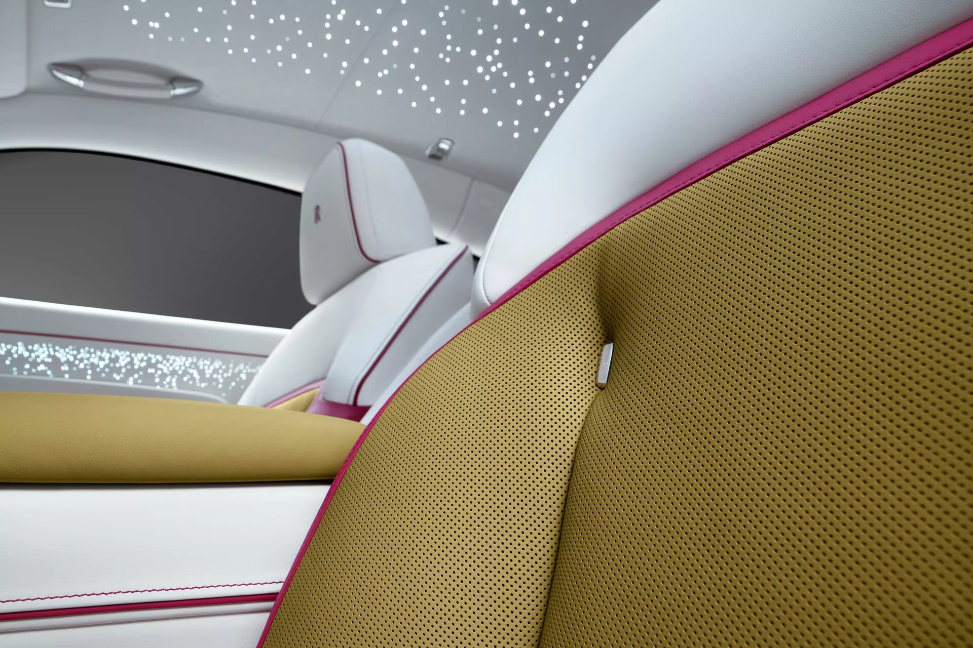 Visão detalhada do interior do Rolls-Royce Spectre 2023 enfatizando luxo com assentos em dois tons, costura detalhada, forro com luzes que imitam um céu estrelado e materiais premium