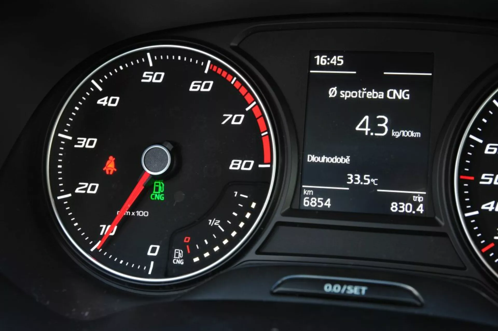Vista detalhada do painel de instrumentos do Seat Leon SC 2016 apresentando velocímetro analógico, conta-rotações e display multifunção com consumo de CNG, hora, temperatura e leituras do odômetro de viagem