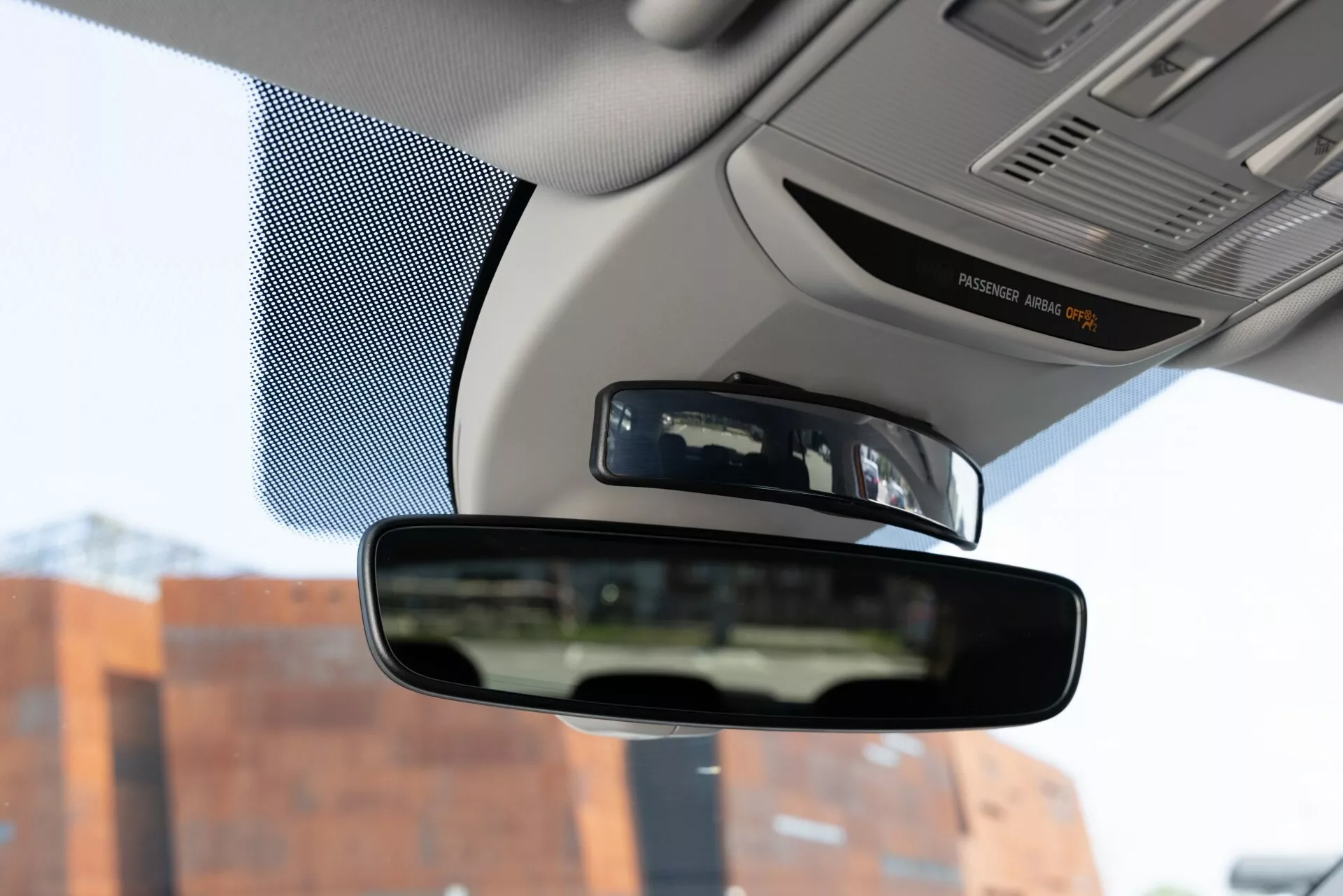 Vista interior do Skoda Fabia 2021, focando no retrovisor a partir da perspectiva do assento do motorista, capturando o espelho, partes do painel e as bordas do para-brisa.