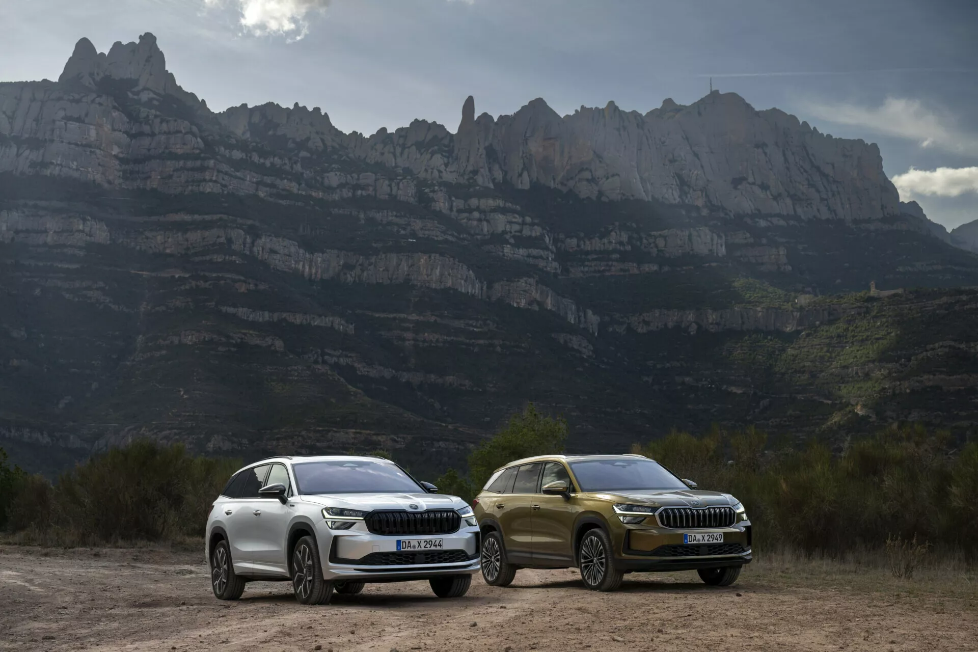 SUVs Skoda Kodiaq 2024 com luzes LED e detalhes de design de luxo estacionados ao ar livre contra um cenário montanhoso, destacando características aerodinâmicas, rodas de liga leve e tecnologia avançada adequada para condução aventureira.