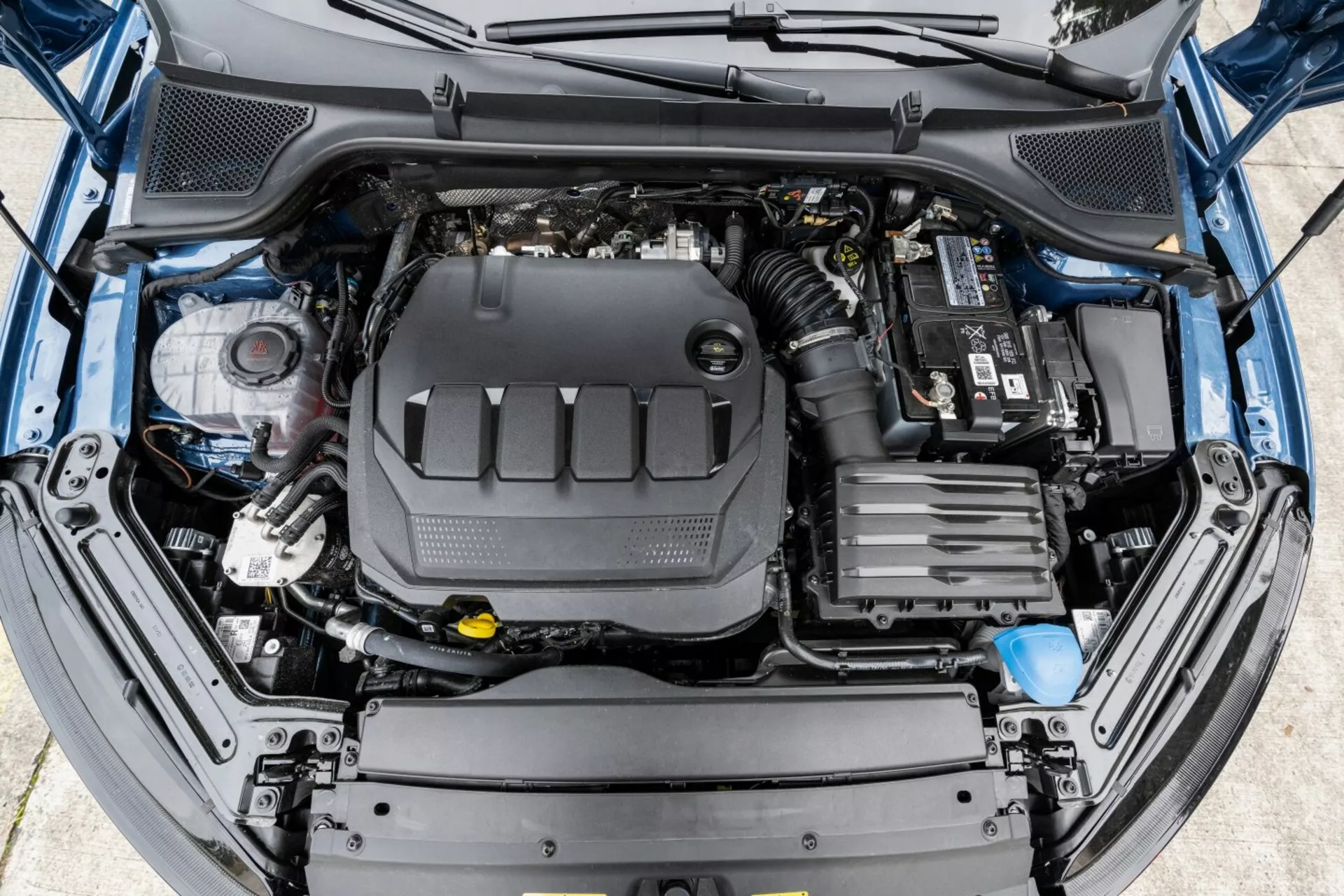 Vista de cima para baixo do compartimento do motor de um Skoda Octavia 2017 com o capô aberto, destacando os principais componentes do motor e design facilitador de manutenção