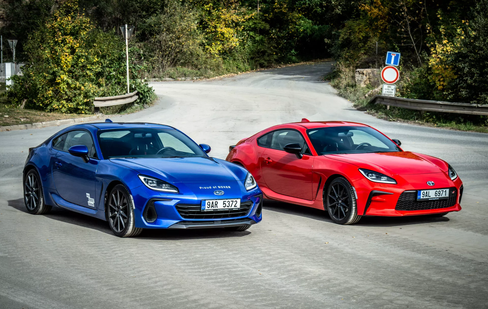Duo Subaru BRZ 2023 exibindo carros esportivos estilo coupé em azul vibrante e vermelho marcante estacionados lado a lado no asfalto com elementos de design aerodinâmico, faróis LED modernos e rodas orientadas para o desempenho sob luz natural do dia