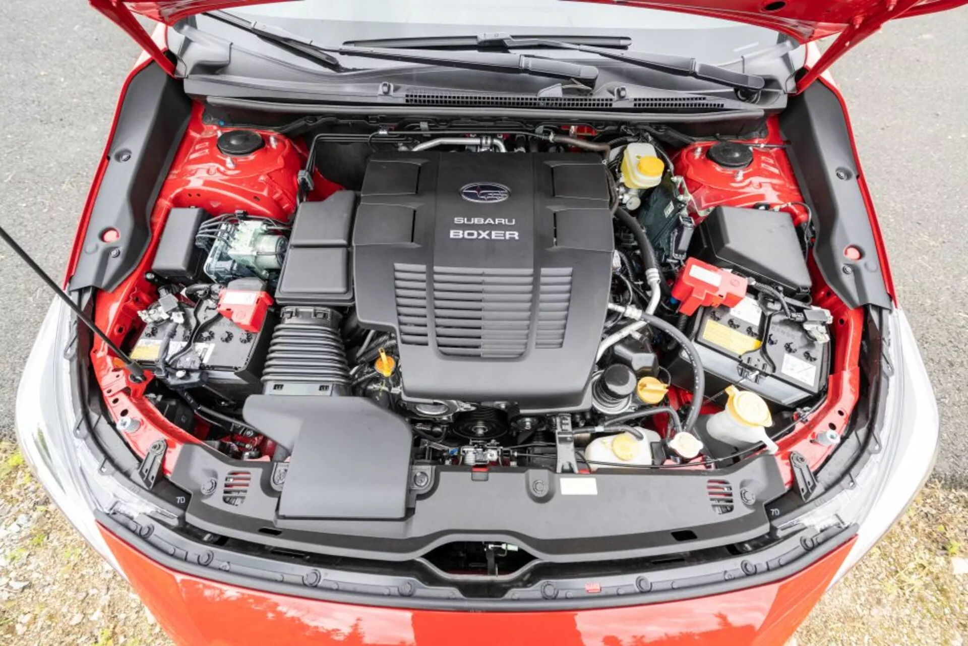 Vista detalhada do compartimento do motor aberto de um Subaru Impreza 2018 com motor Subaru Boxer, mostrando componentes mecânicos e elétricos de um ângulo elevado