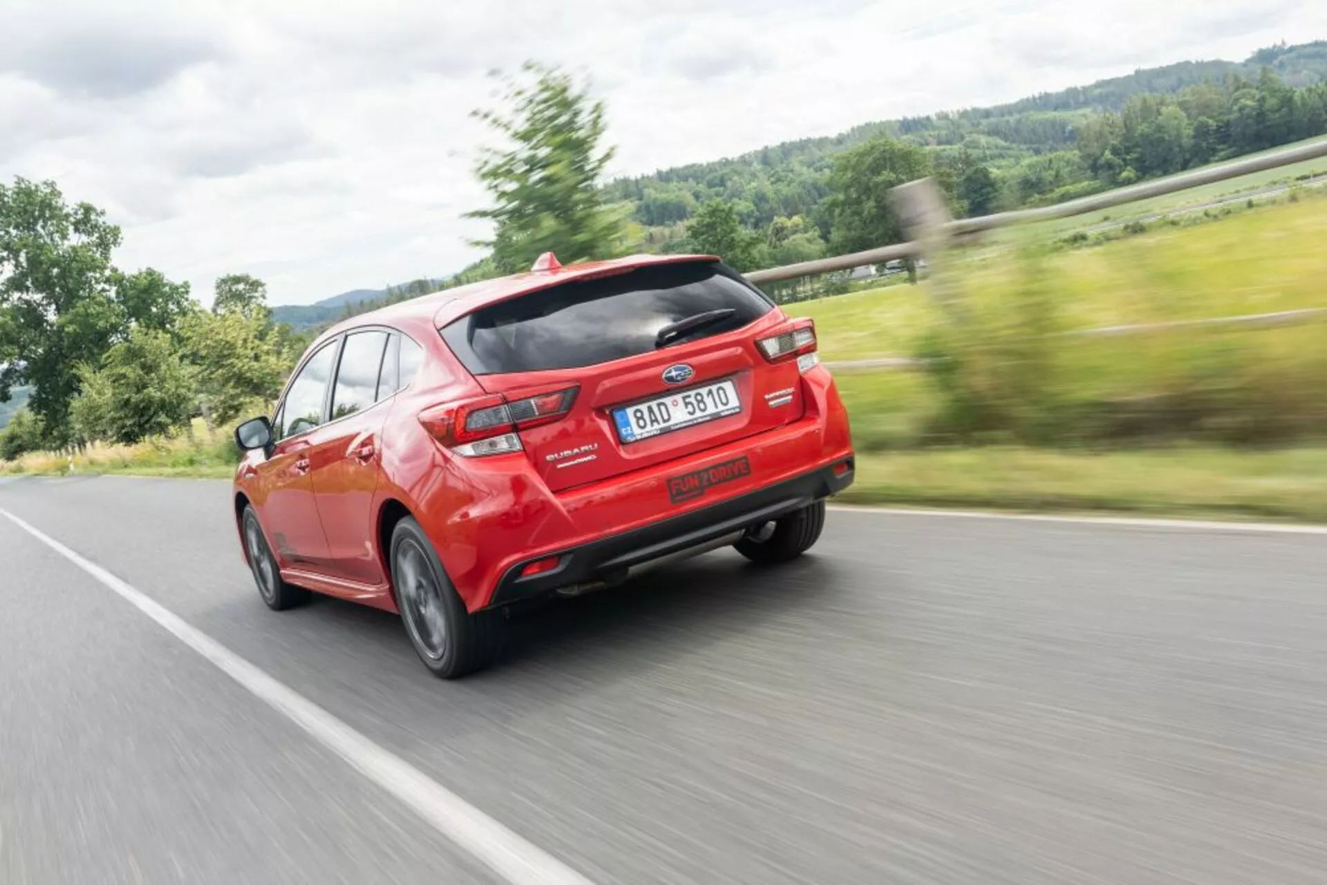 Subaru Impreza 2018 em vermelho vibrante, exibindo design moderno com spoiler traseiro aerodinâmico e escape duplo, capturado de um ângulo traseiro de três quartos, enfatizando velocidade e linhas de design.