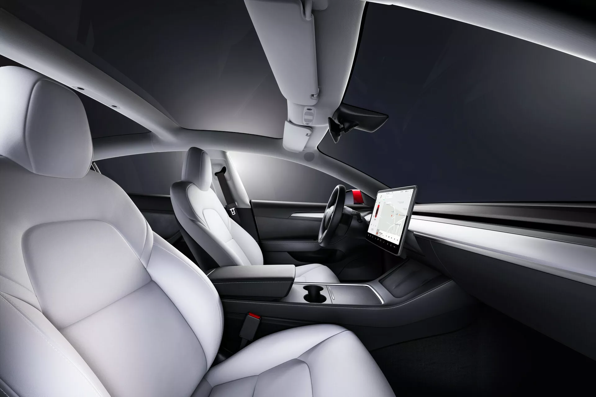 Vista interior do Tesla Model 3 de 2019, Primeira Geração, destacando a área do motorista e do passageiro dianteiro a partir de uma perspectiva traseira elevada. As características incluem assentos contornados de couro de cor clara para conforto e suporte lateral, uma tela sensível ao toque vertical proeminente para multimídia e configurações do veículo, um painel minimalista e elegante com controles integrados, um volante de três raios de estilo esportivo com botões multifuncionais e um console central aerodinâmico com elementos de design minimalista e porta-copos.