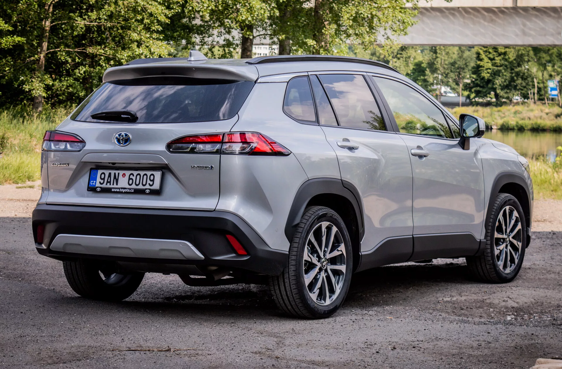 SUV compacto híbrido Toyota Corolla Cross 2022 exibindo lanterna traseira LED avançada, rodas de liga leve e recursos de segurança a partir de uma visão traseira de três quartos.