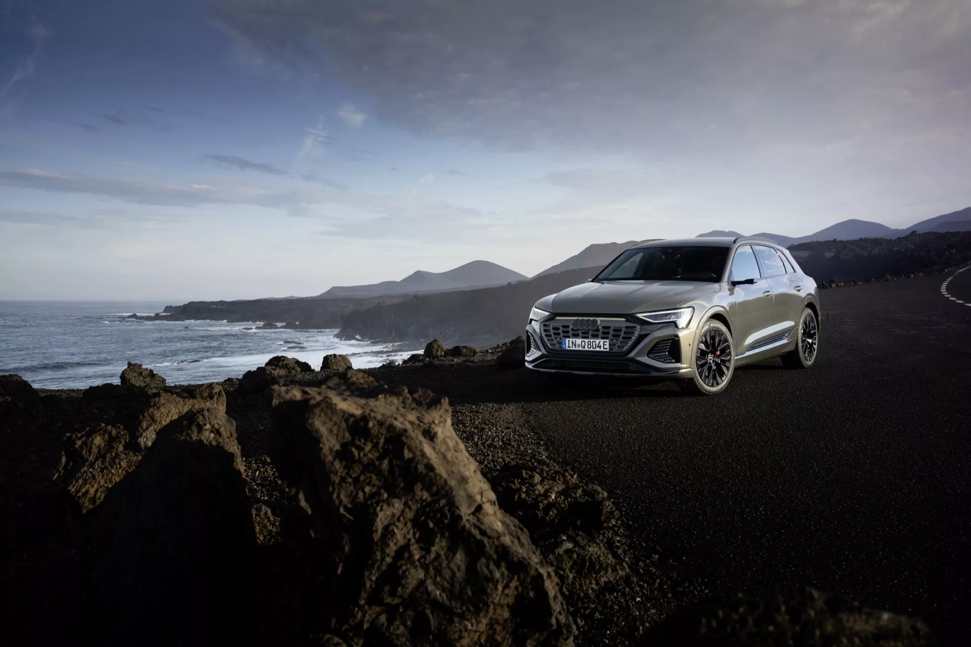 Vista lateral frontal do Audi Q8 E-Tron GE 2023 em azul metálico na autoestrada