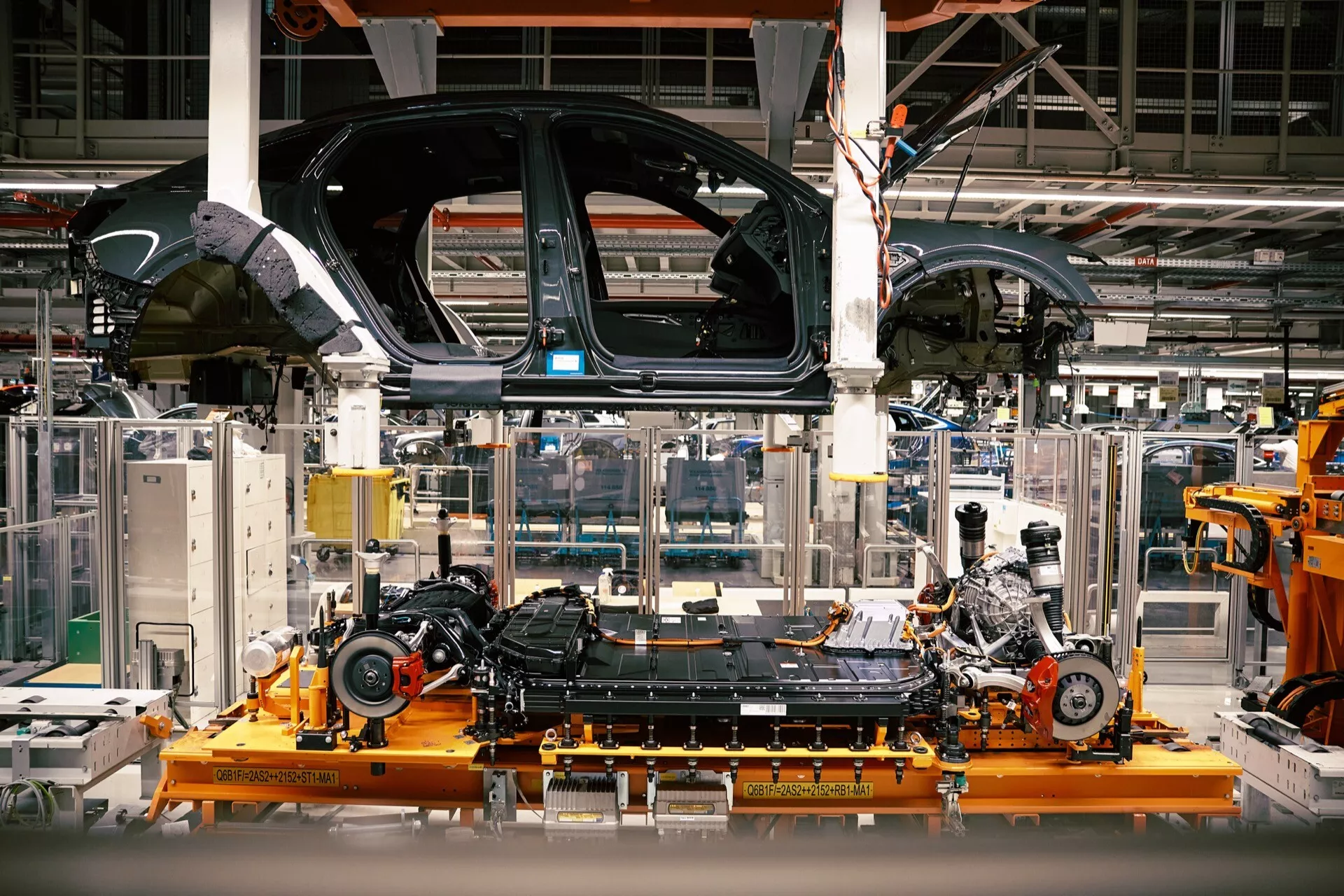 Audi Q8 e-tron 2023 em montagem parcial na linha de fábrica, mostrando chassi e instalação do motor dentro de uma planta automotiva