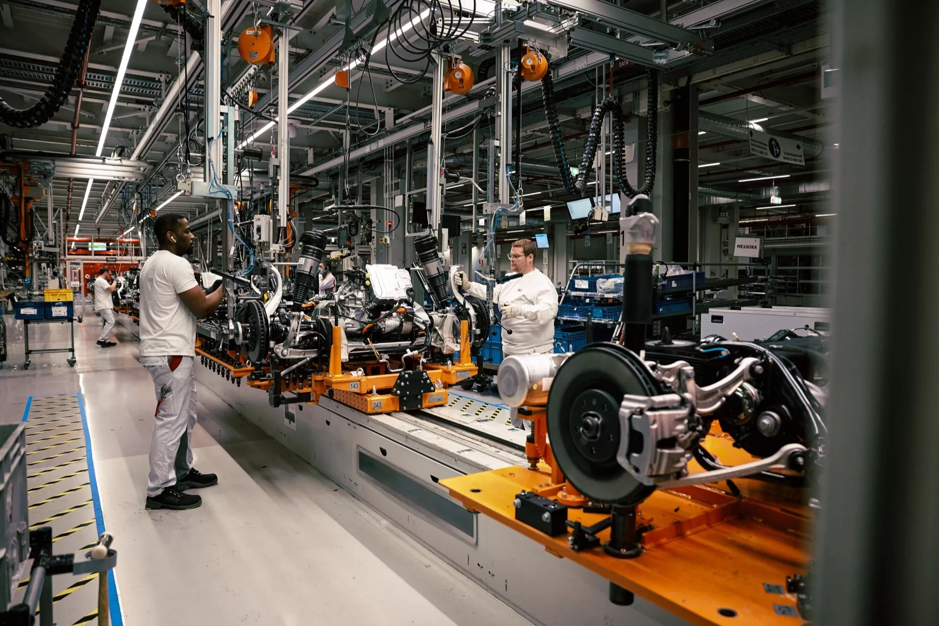 Chassi do Audi Q8 e-tron 2023 na linha de montagem em fábrica, mostrando construção em estágio inicial, sistema de suspensão traseira e tecnologia da linha de produção