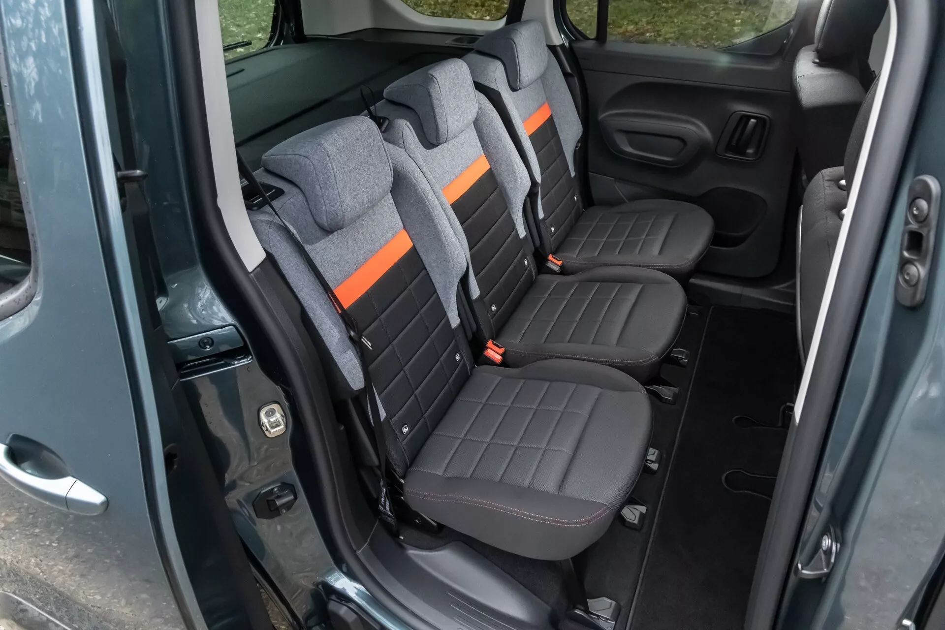 Interior do Citroen Berlingo 2024 mostrando área dos passageiros traseiros com assentos em dois tons e recursos avançados de uma vista diagonal