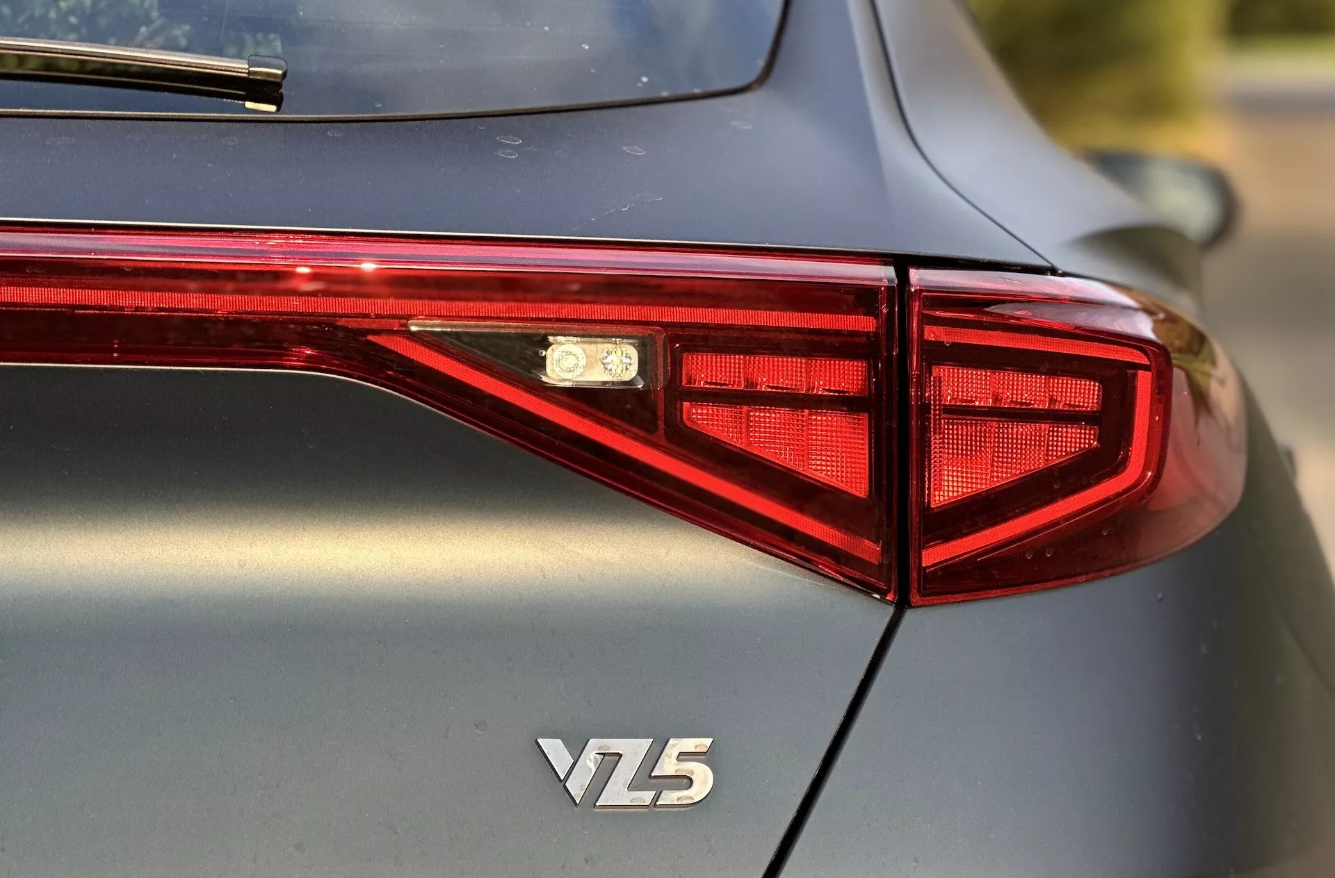 Vista traseira de um Cupra Formentor VZ5 2020 focando no design da luz traseira LED, emblema e carroceria metálica de alta qualidade, capturada de um ângulo de três quartos com profundidade de campo reduzida