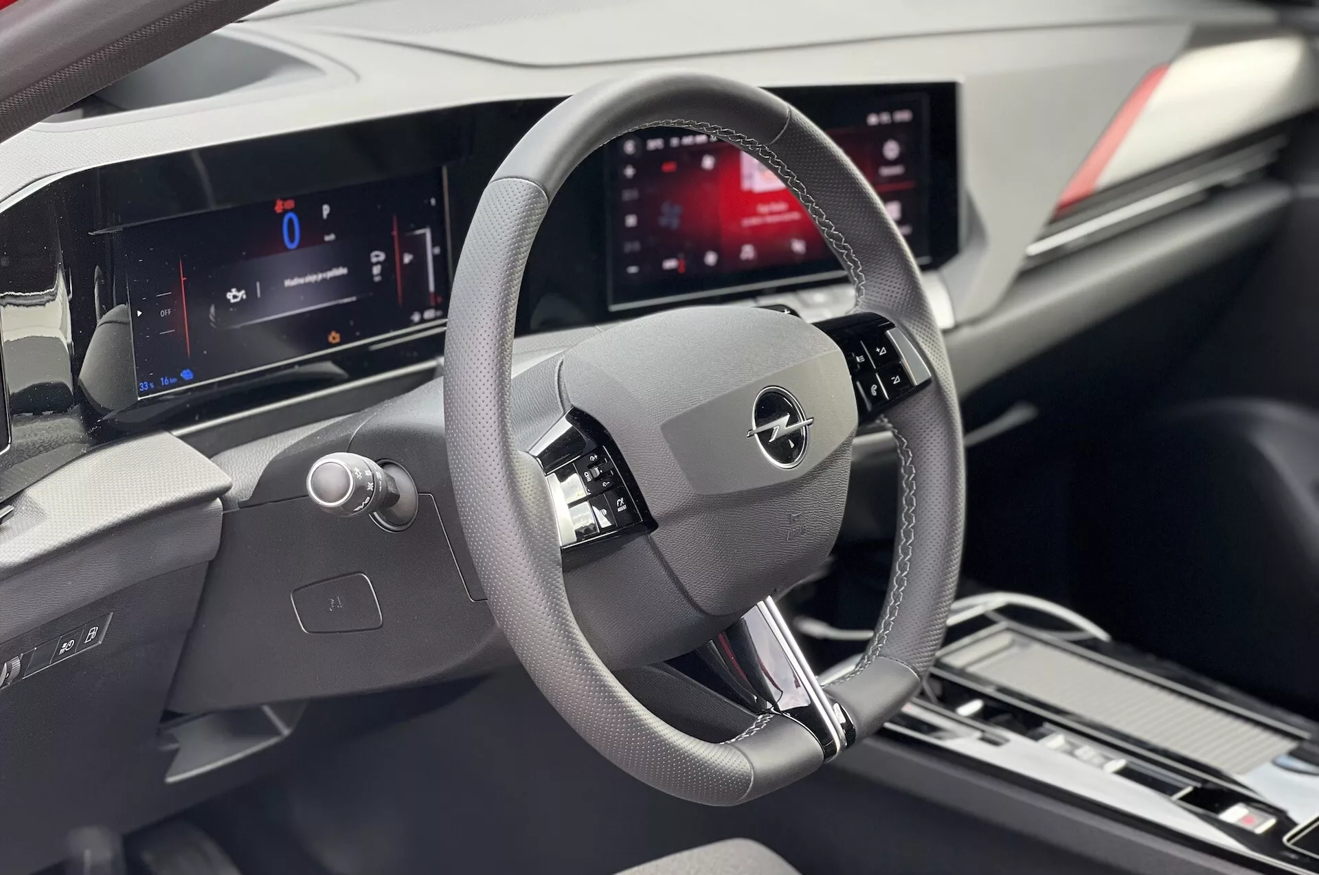 Vista interior de um Opel Astra 2022 focada na área do condutor com volante detalhado, painel de instrumentos digital e tela de infotainment central