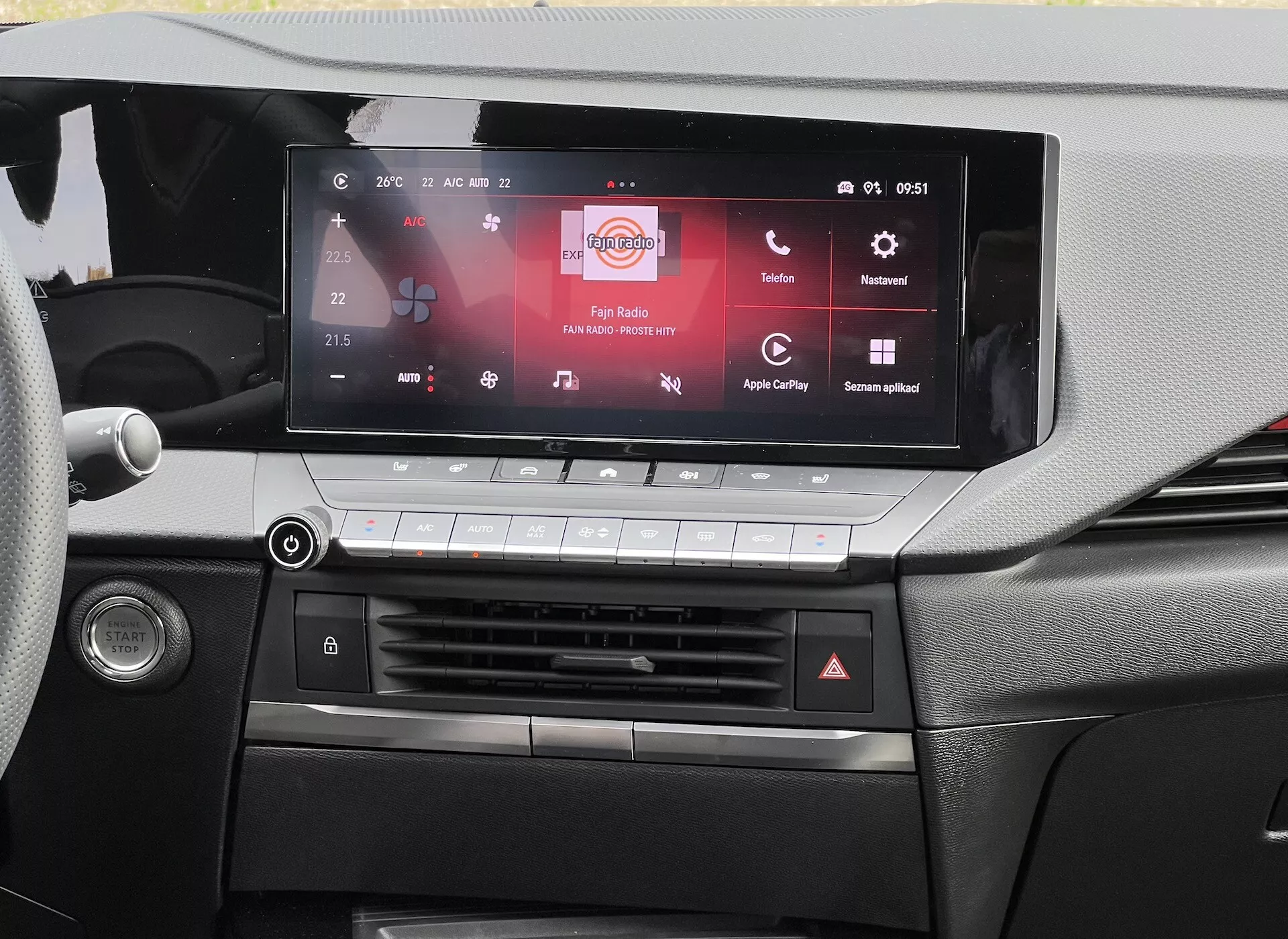Visão do painel do Opel Astra 2022 destacando a tela sensível ao toque do sistema de infotenimento compatível com Apple CarPlay e Android Auto, sistema de controle climático e design detalhado da cabine