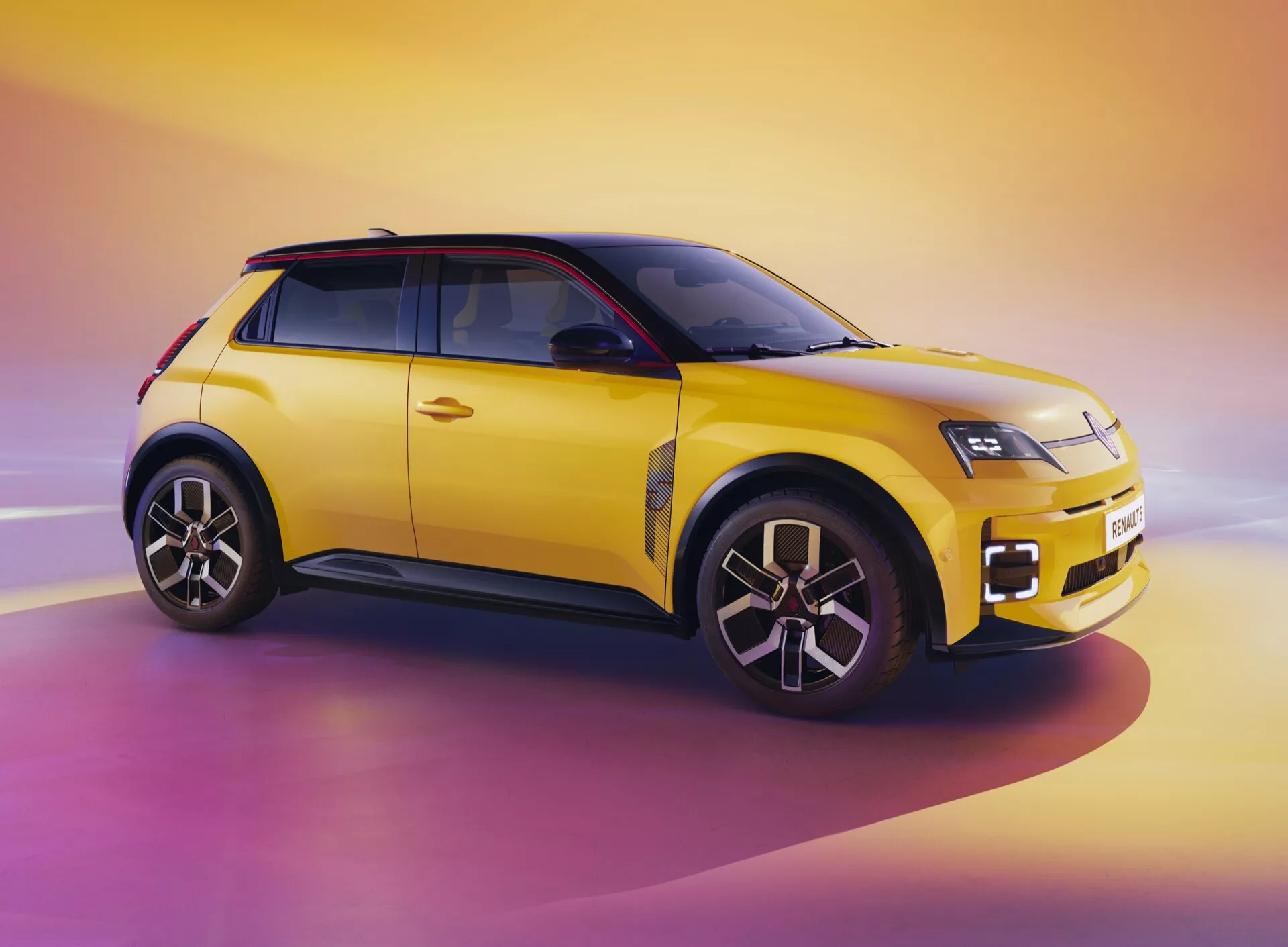 Renault R5 III 2024 em amarelo vibrante com teto preto exibindo seu design moderno de SUV compacto sob um ângulo frontal de três quartos, destacando faróis LED, rodas de liga leve multiraiadas e esquema de cores em dois tons contra um pano de fundo dinâmico de nascer do sol